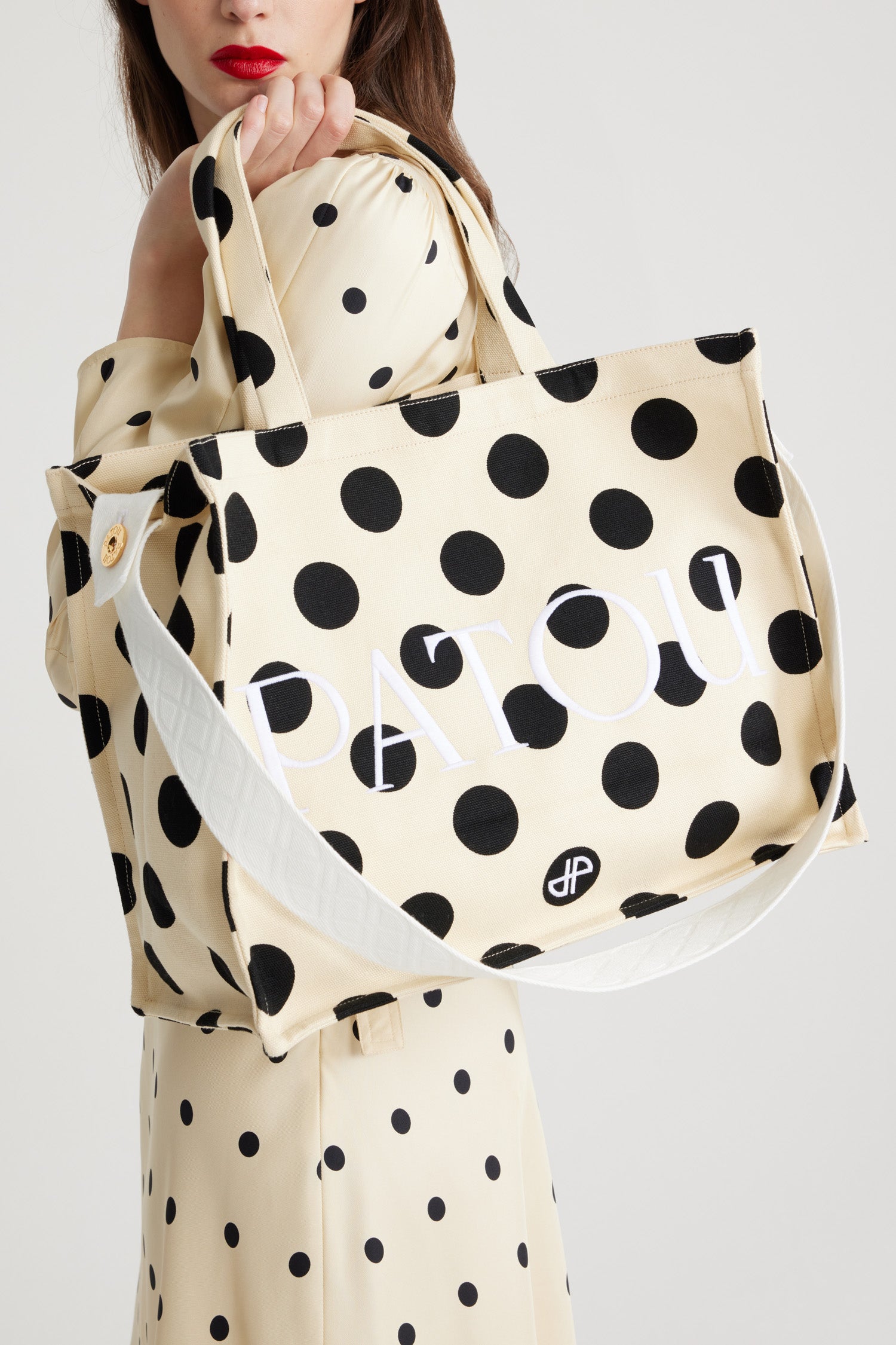 Patou - Large JP tote in printed cotton canvas - Angora Dots - Angora off-white cotton canvas tote. Polka dot pattern. Large version. Embroidered Patou and JP. Embossed shoulder strap with gold buttons. Two top handles. Can be carried by hand or on the shoulder.