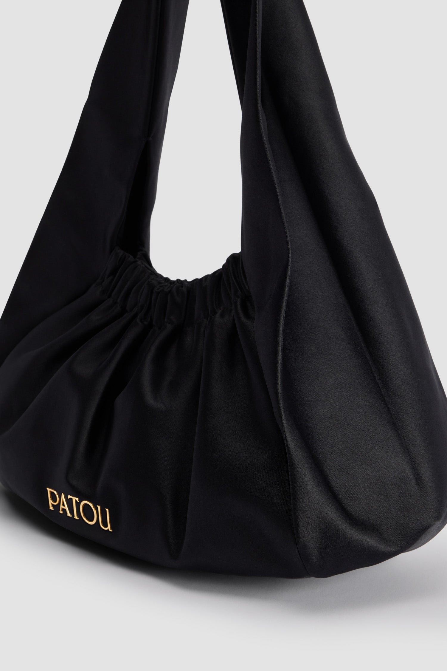 Patou - Die Le Biscuit Tasche - Black - Tasche aus Baumwollmisch-Satin in Schwarz. Großes Modell. Hobo-Form mit integriertem, breiten Riemen. Öffnung mit Gummizug. Patou-Logo aus goldfarbenem Metall. Baumwollfutter.