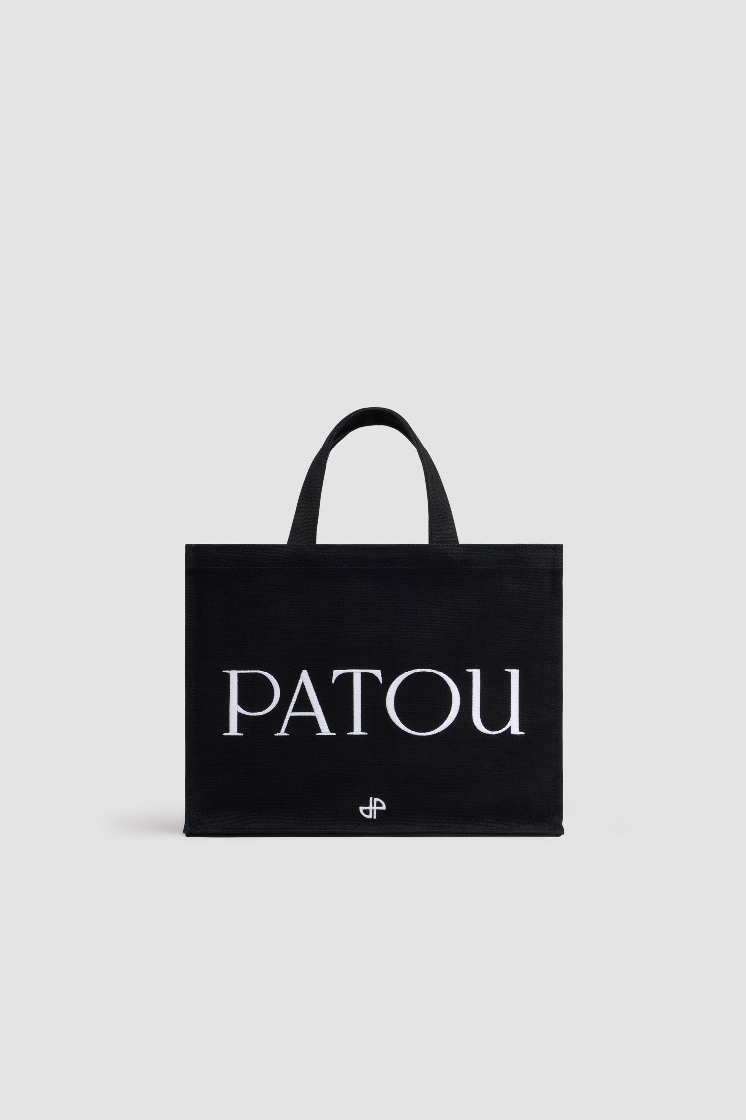 Patou - コットンキャンバス パトゥ ロゴトート ミディアム - Black - ブラックのコットンキャンバス製トート。ミディアムサイズのバージョン。パトゥの刺しゅうロゴとJPモノグラム。エンボス加工のショルダーストラップ、ゴールドトーンのパトゥロゴ刻印入りボタン。2つのトップハンドル。ハンドバックあるいはショルダーバックとしてご使用いただけます。
