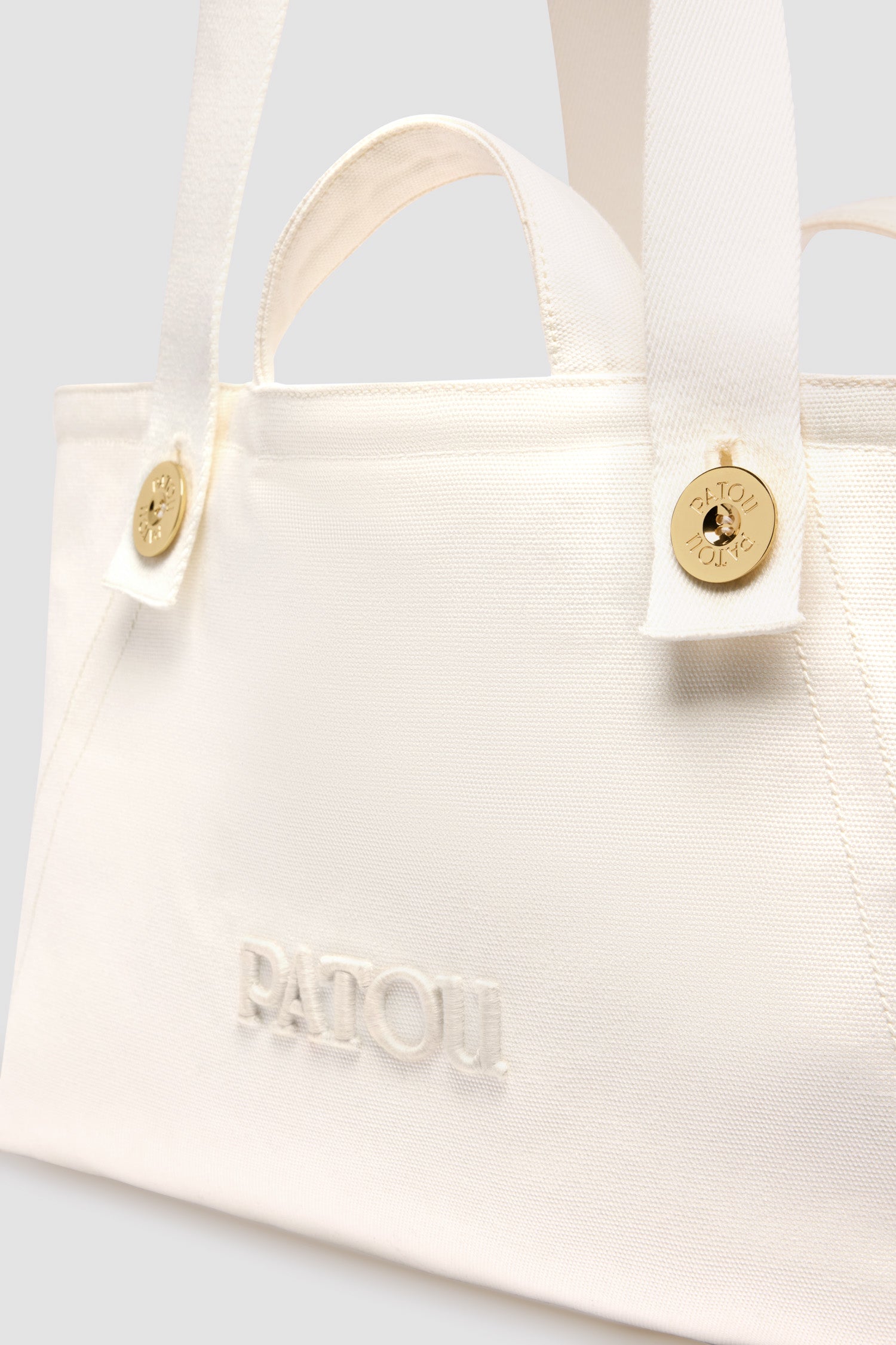 Patou - Tote a trapezio grande con logo Patou in cotone - White - Borsa in cotone bianco. Modello grande. Forma trapezio. Doppio manico, due tracolle con bottoni oro incisi con il logo Patou. Logo Patou ricamato sul davanti.