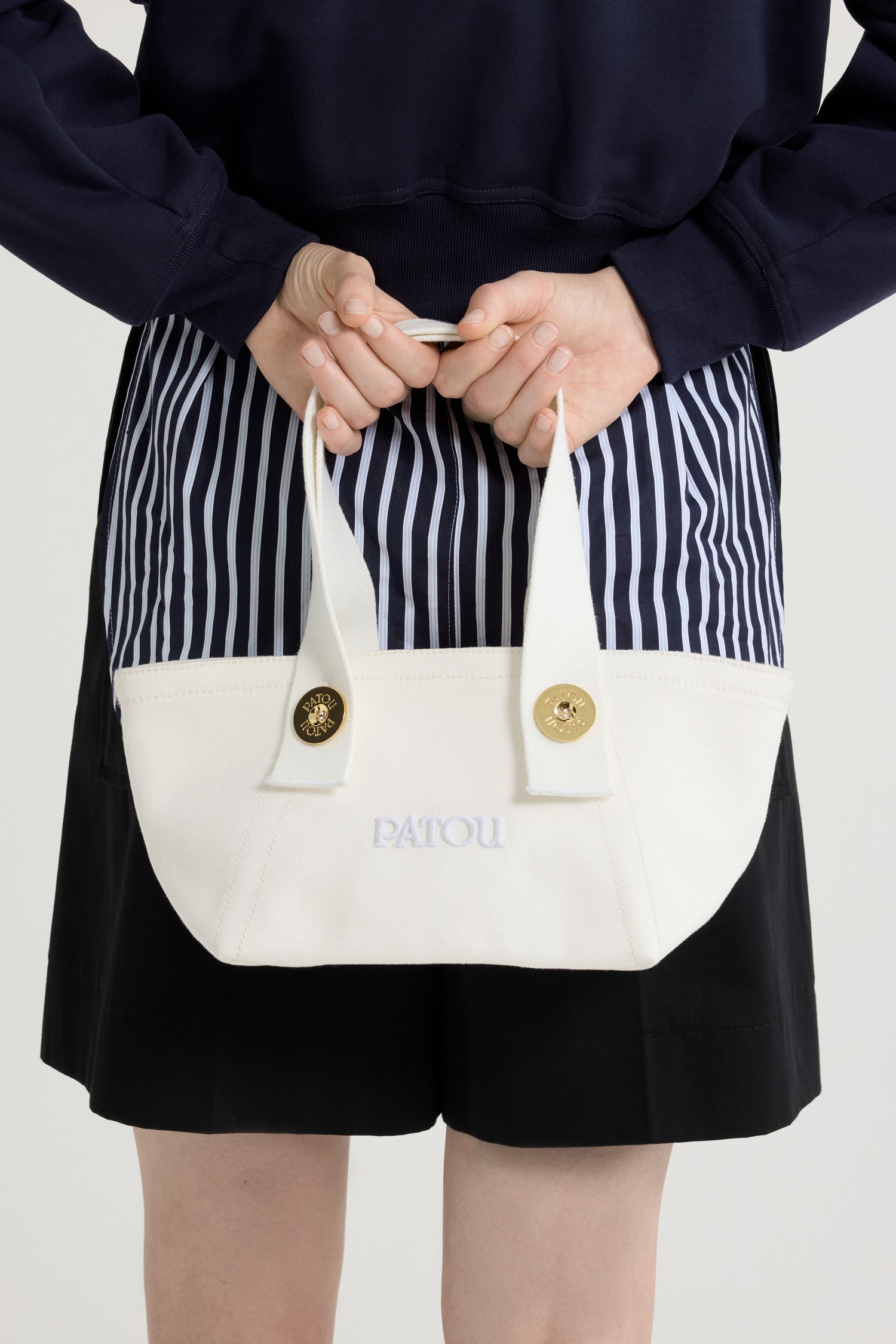 Patou - コットンキャンバス パトゥ ロゴ トラペーズ トート スモール - White - ホワイトのコットンキャンバス製トート。スモールバージョン。台形シェイプ。トップハンドル 2本、ショルダーストラップ 2本がゴールドトーンのパトゥロゴ刻印入りボタンで付属。フロントにパトゥの刺繍ロゴ。