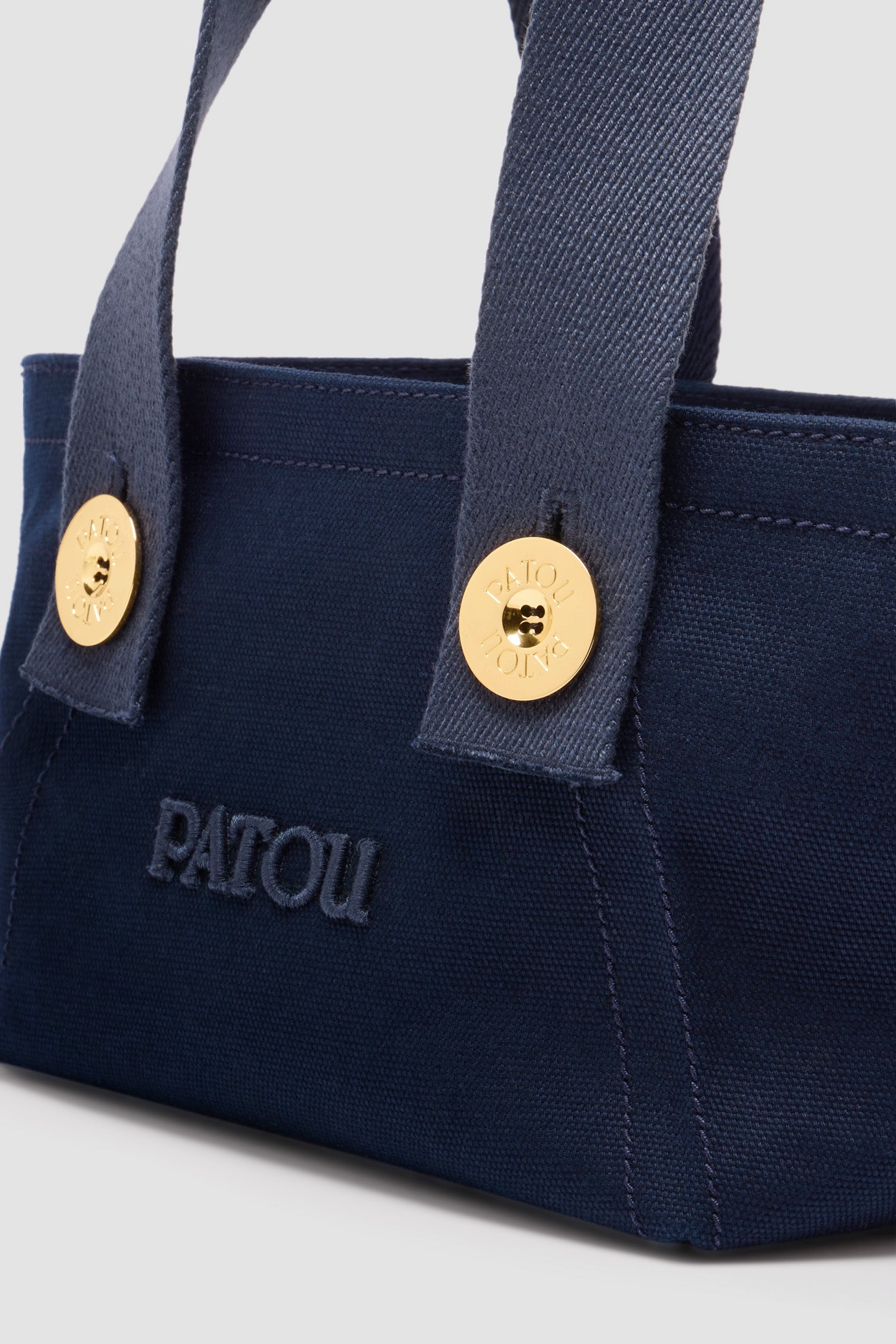 Patou - Tote a trapezio piccola con logo Patou in cotone - Navy Black - Borsa in cotone blu nero. Modello piccolo. Forma trapezio. Doppio manico, due tracolle con bottoni oro incisi con il logo Patou. Logo Patou ricamato sul davanti.