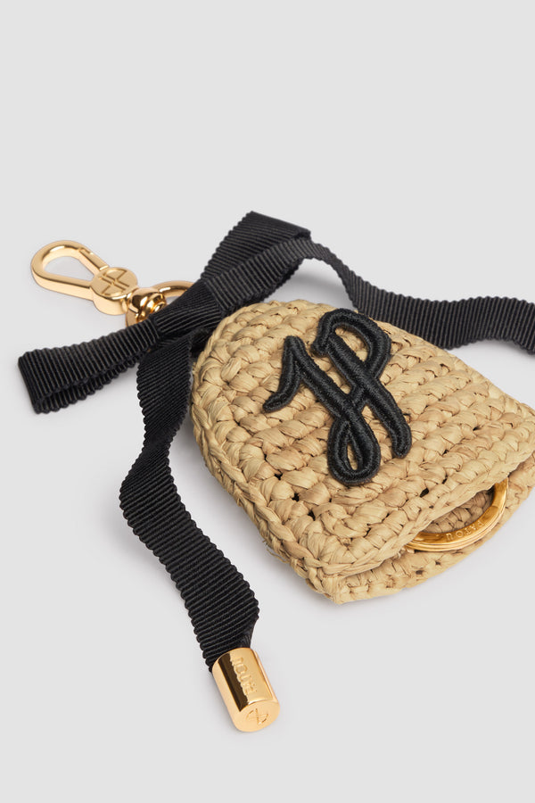 Patou - Schlüsselanhänger aus Raffiabast - Vanilla - Vanillefarbener Schlüsselanhänger aus Raffiabast. Goldfarbener Hakenverschluss mit eingraviertem JP-Monogramm, befestigt an einer schwarzen Schleife aus Grosgrain mit Metallspitzen. Kontrastfarbene JP-Monogramm-Stickerei. Verdeckter Schlüsselring mit Patou Logogravur. Dieses Produkt wurde von Hand gefertigt.
