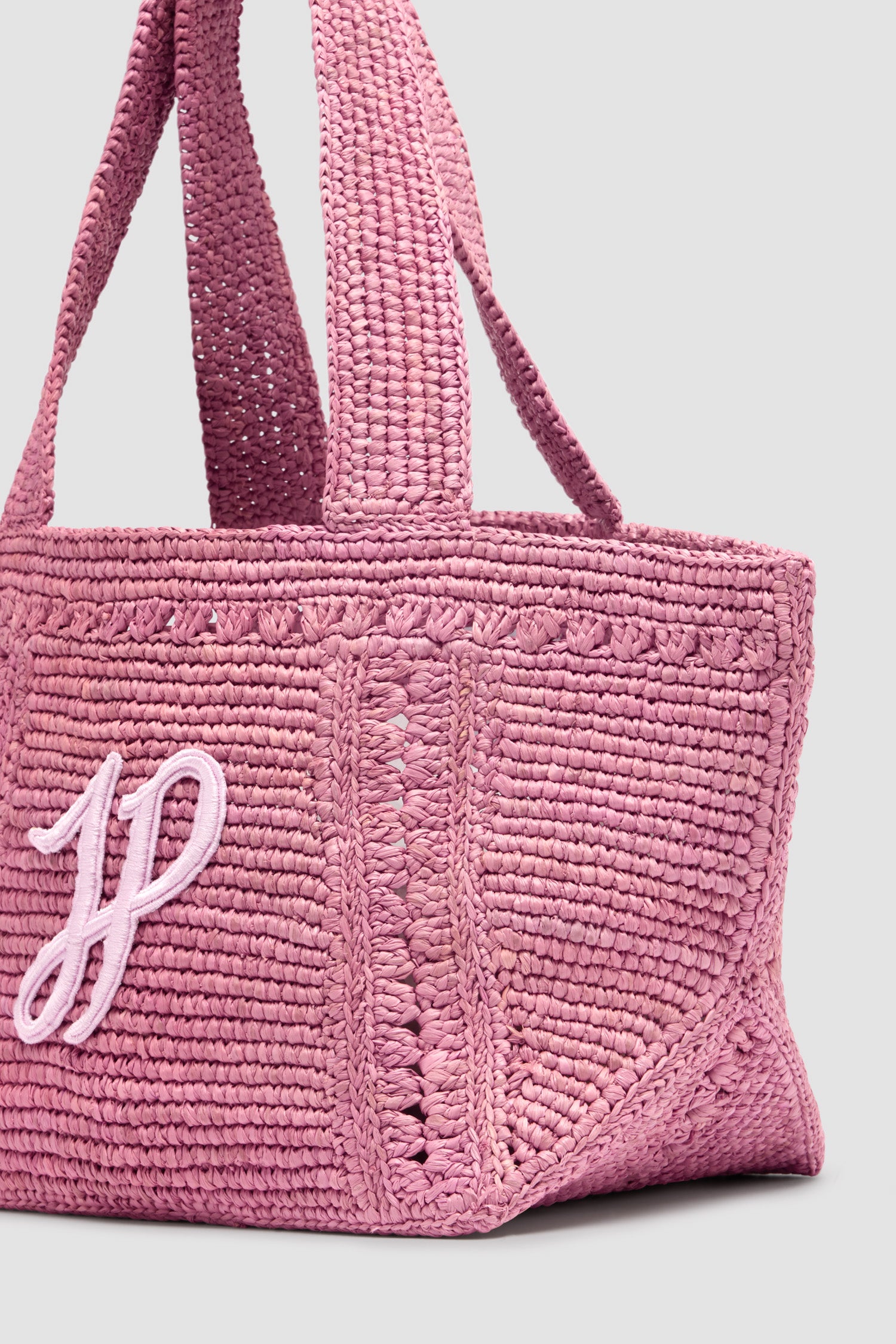 Patou - Small JP monogram trapeze tote in raffia - Primrose Pink - Primrose Pink raffia tote. Small version. Trapeze shape. Two shoulder straps. Tonal JP monogram embroidery at the front.This style was lovingly handcrafted by one of the artisans trained at the Ecole des Savoir Faire.