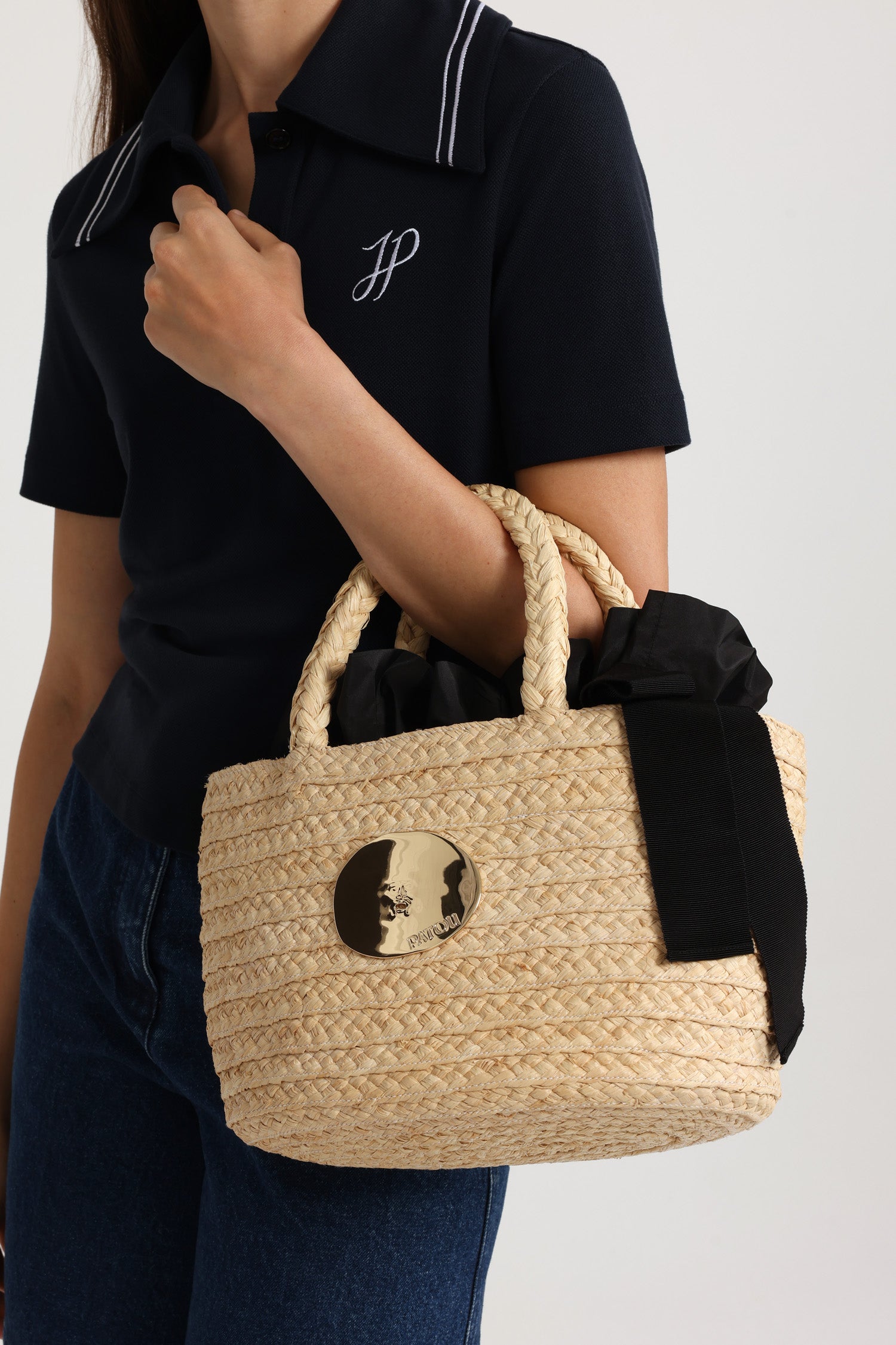 Patou - Panier en raphia - Vanilla - Panier en raphia naturel couleur vanille. Double anse tressée. Décoration dorée inspirée par la "Bocca della Verità". Doublure en tissu noir avec volant et lien en gros-grain.