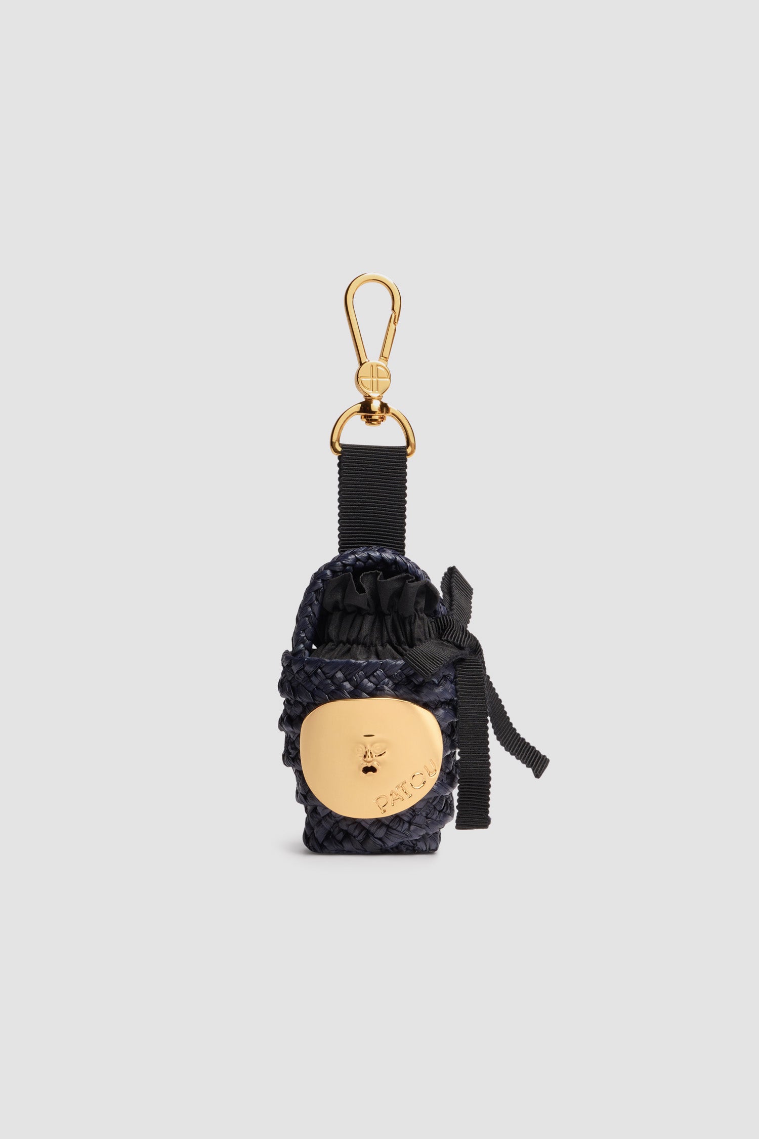 Patou - Charm in rafia - Navy Black - Charm in rafia blu nero. Chiusura con gancio oro inciso con il monogramma JP e grosgrain con punte oro. Decorazione oro ispirata alla Bocca della Verità. Interno in tessuto ton sur ton con balza e fiocco.