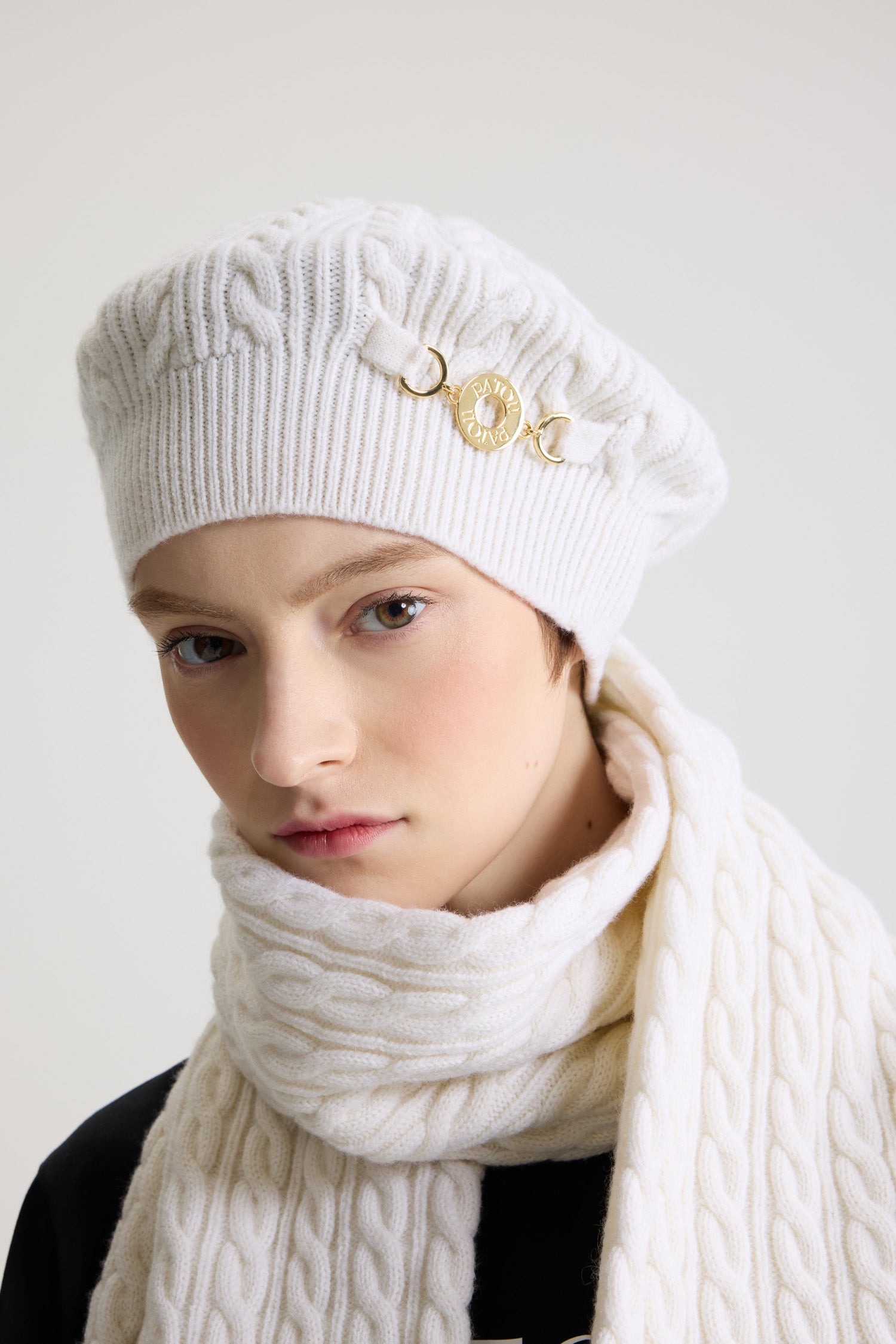 Patou - ウール&カシミヤ ケーブルニット ベレー - Snowberry White - スノーベリーホワイトのウール&カシミア製ベレー。ケーブルニット。リブ編みのブリム。フロントにゴールドトーンのパトゥロゴ刻印入りメダリオン装飾。