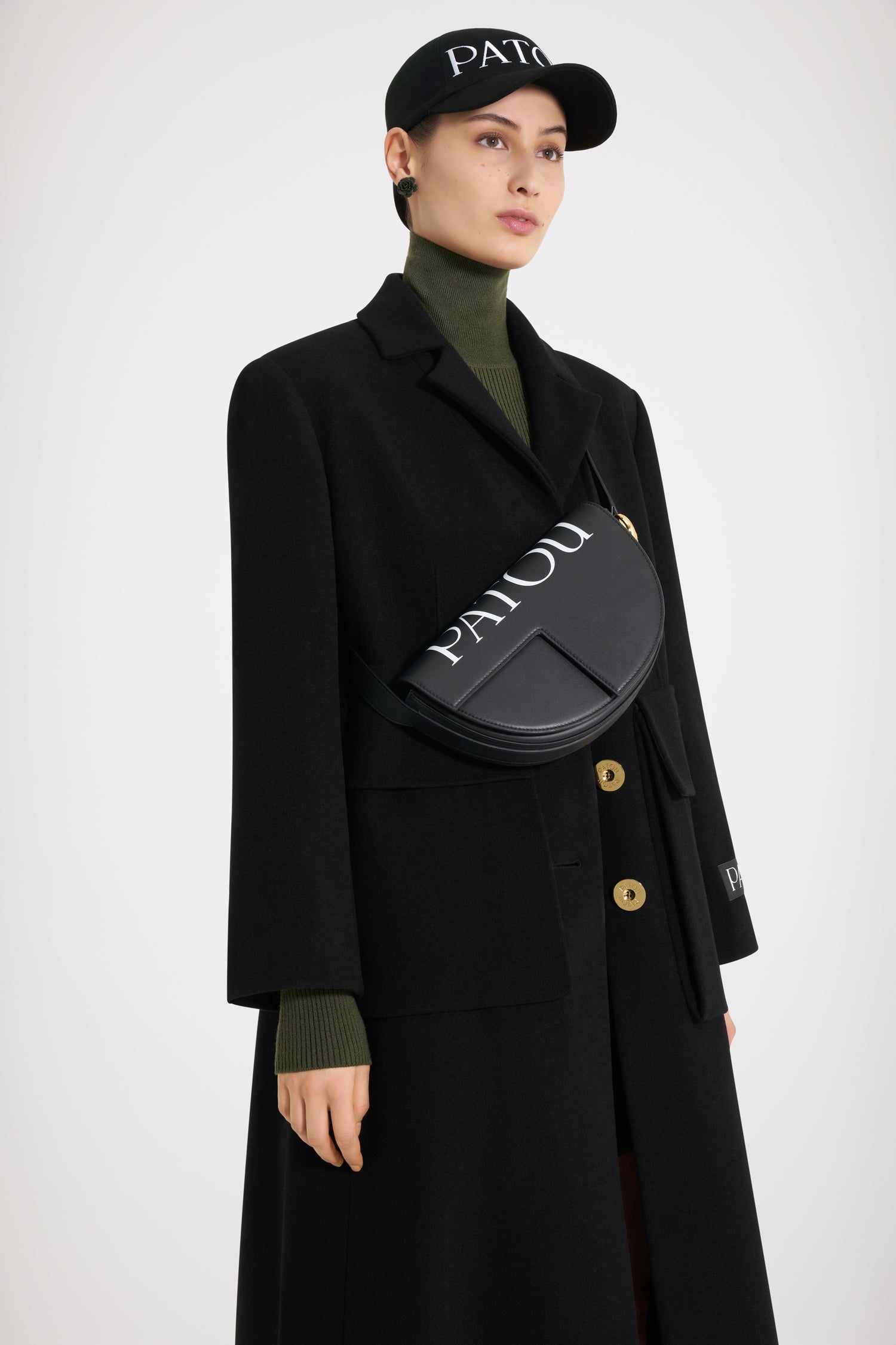 Patou - Le Patou バッグ - Black and White - バッグを超えたパトゥ バッグ!ブラックのレザーハンドバッグ。未使用レザーから持続可能な方法により調達した独自の素材で作られた限定エディション。番号入り120点限定エディション。JPモノグラムにインスピレーションを得た幾何学的なカットアウトをあしらった半円形のフォルム。ホワイトのパトゥ レタリングロゴ。サイドにゴールドトーンのメタルパーツとJPモノグラム ディテール。パトゥ刻印入りメタルパーツが付いた調整可能なストラップで、ショルダーバッグ、クロスボディバッグ、ハンドバッグとしてお使いいただけます。ゴールドトーンのJPディテールをあしらったマグネットクロージャー。内部に複数のコンパートメント。エコライニング。長さ: 25 cm高さ: 15 cm幅:6 cmストラップの長さは3段階で調節可能:47 cm (ショルダー)、36 cm (クロスボディ)、28 cm (ハンド)