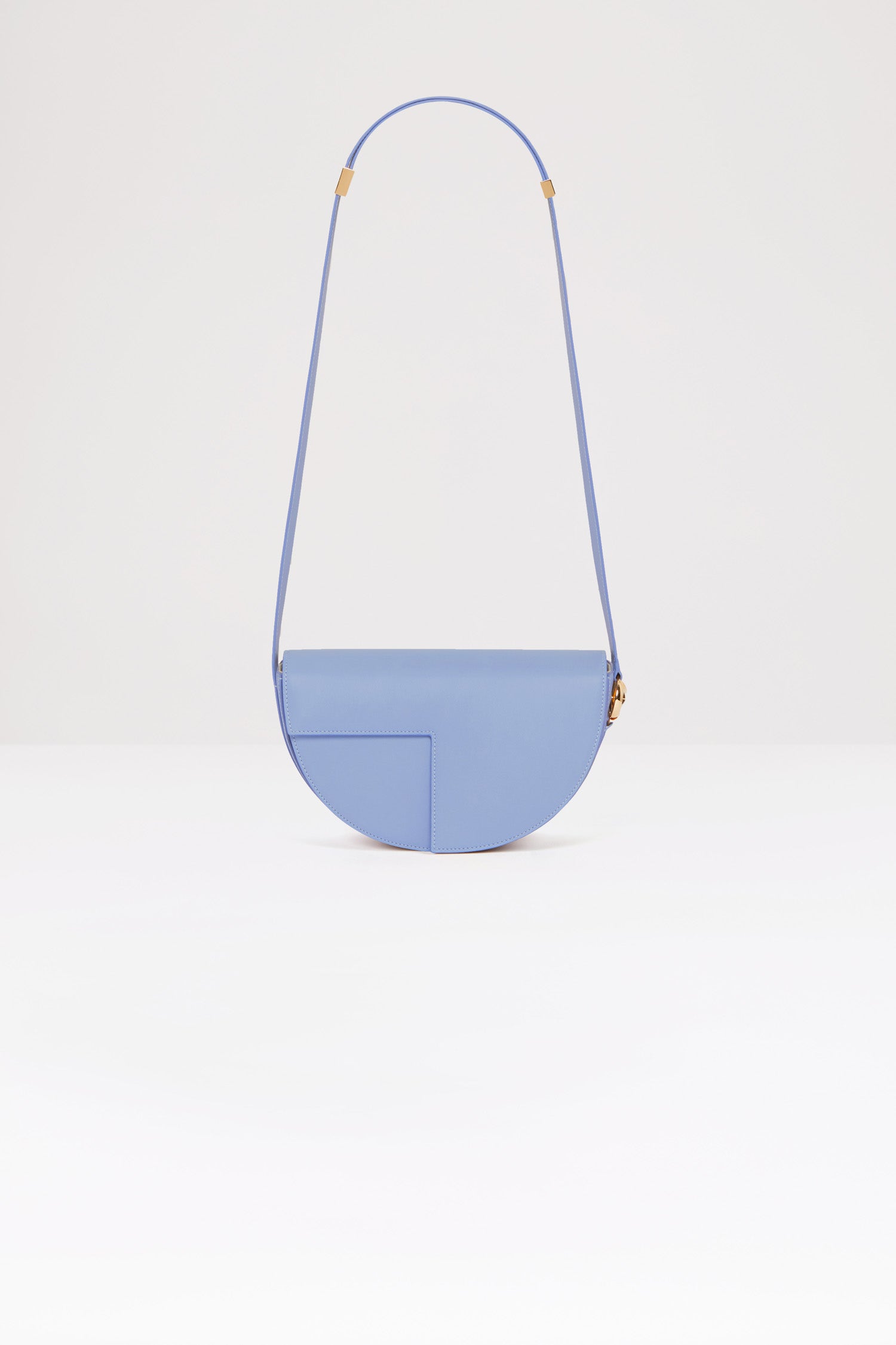 Patou - Le Patou - Aurora - Le Patou is out of the bag!Aurora light blue leather handbag. Crafted using unique materials sourced from unused high quality leather hides. 120 limited numbered edition. Half-circle shape with geometric cut-outs inspired by the JP monogram. Gold-tone hardware with JP monogram detail at the side. Adjustable strap that allows it to be worn on the shoulder, across the body or carried by hand. Magnetic closure with gold-tone JP detail. Multiple compartments inside.Measures: 25cm long, 15cm high and 6cm deep3 lengths for the adjustable strap: 47 cm (on the shoulder), 36 cm (across the body), 28 cm (carried by hand).