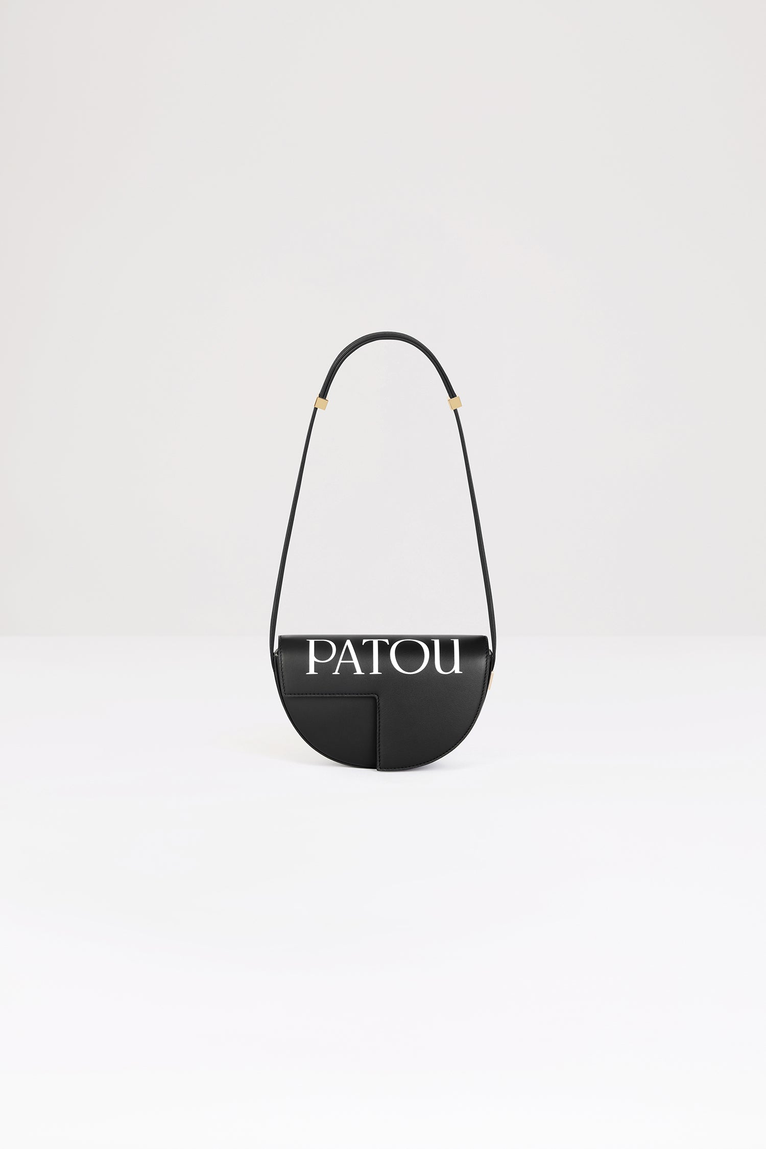 Patou - Le Petit Patou Logo Tasche aus Leder - Black and White - Eine kleinere Version des absoluten Patou Lieblings!Handtasche aus Leder in Schwarz. Aufgedrucktes Patou auf der Oberseite. Gefertigt aus einzigartigen Materialien, die aus unverwendeten hochwertigen Lederhäuten gewonnen wurden. 160 nummerierte Exemplare in limitierter Auflage. Halbkreis-Format mit geometrischen, vom JP-Monogramm inspirierten Cut-Outs. Goldfarbene Metallelemente mit Patou Gravurdetail an der Seite. Verstellbarer Riemen zum Tragen über der Schulter, diagonal am Körper oder in der Hand. Magnetverschluss mit goldfarbenem JP-Detail. Innenfach. Öko-Futter.Maße: 20 cm (Länge), 13 cm (Höhe), 5 cm (Breite)