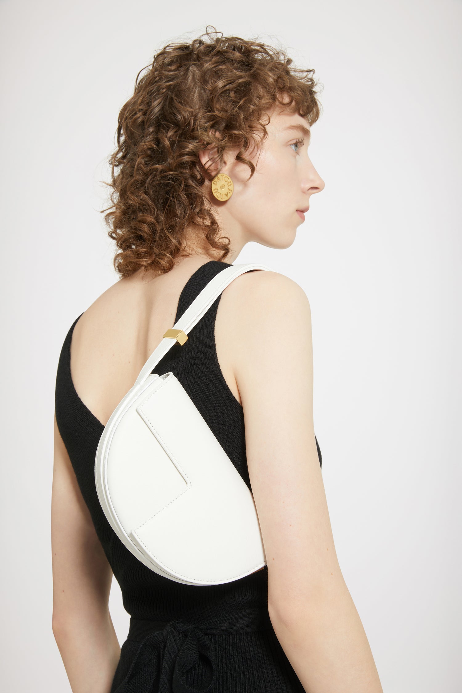 Patou - Le Petit Patou - Avalanche - Le Petit Patou a tout d'un grand !Sac en cuir blanc avalanche. Réalisé en cuir de grande qualité provenant de stocks dormants issus des surplus de production. Édition limitée et numérotée disponible en 120 exemplaires. Forme demi-lune avec découpes géométriques inspirée du monogramme JP. Pièce métallique gravée Patou sur le côté. Bandoulière ajustable permettant un porté épaule, en bandoulière ou à la main. Fermeture aimantée avec détail JP doré. Doublure éco-responsable.Dimensions : 20 cm de longueur, 13 cm de hauteur et 5 cm de profondeur.