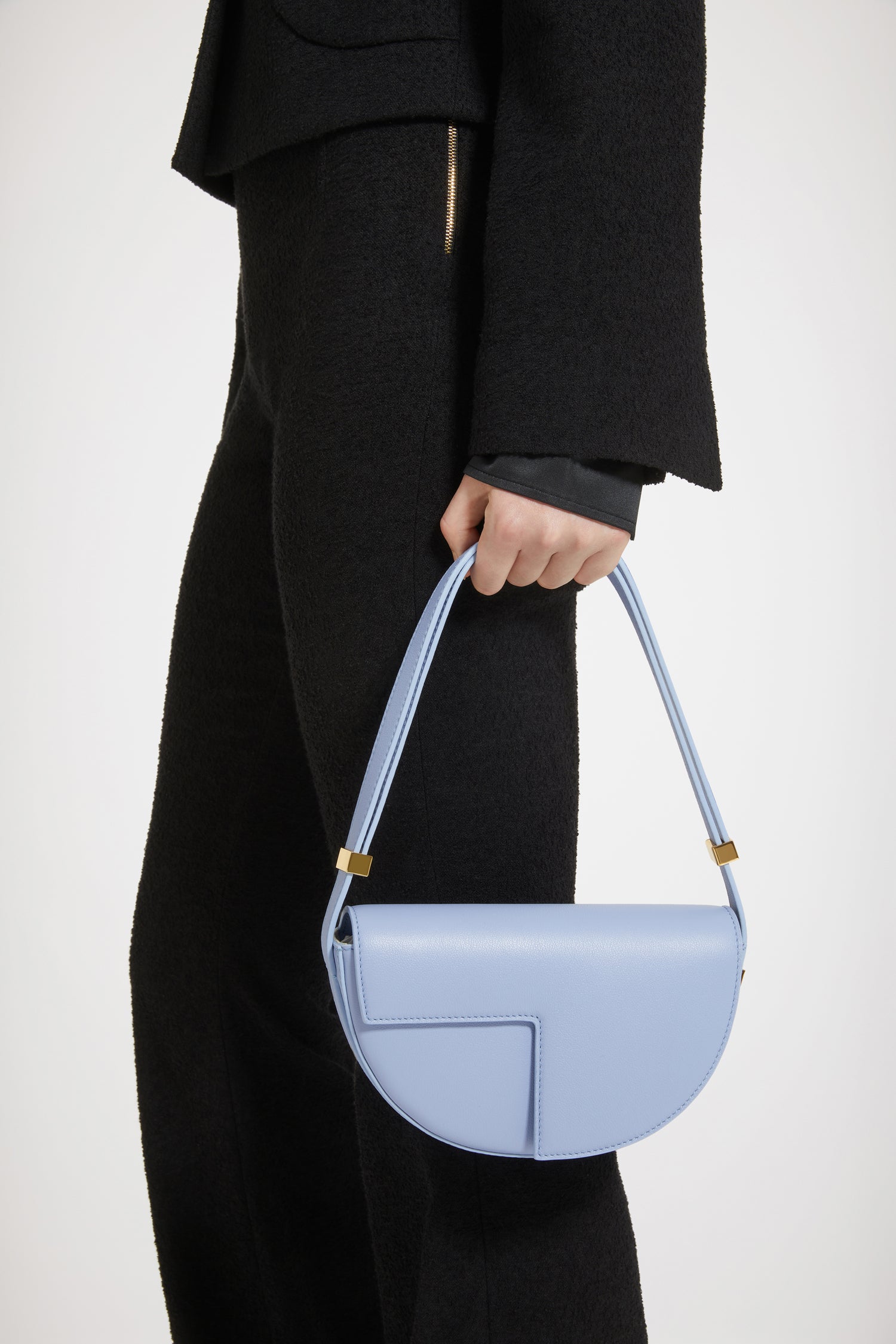Patou - Le Petit Patou bag in leather - Alaska Blue - A smaller take on everyone's favourite piece of Patou!Alaska Blue leather handbag. Crafted using unique materials sourced from unused high-quality leather hides. 120 limited numbered edition. Half-circle shape with geometric cut-outs inspired by the JP monogram. Gold-tone hardware with Patou-engraved detail at the side. Adjustable strap that allows it to be worn on the shoulder, across the body or carried by hand. Magnetic closure with gold-tone JP detail. Internal compartment. Eco lining.Measures: 20cm (length), 13cm (height), 5cm (depth)