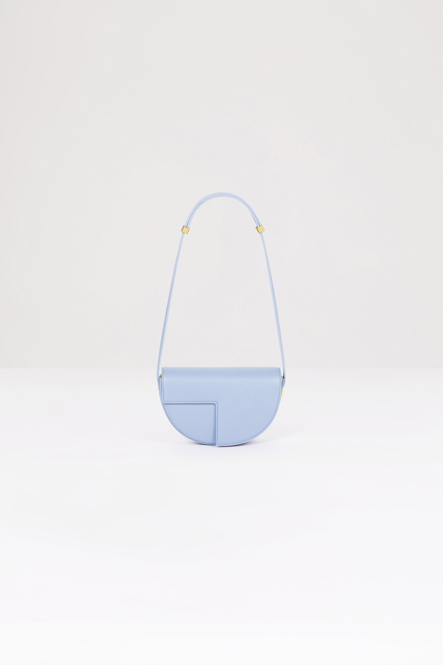 Patou - Le Petit Patou bag in leather - Alaska Blue - A smaller take on everyone's favourite piece of Patou!Alaska Blue leather handbag. Crafted using unique materials sourced from unused high-quality leather hides. 120 limited numbered edition. Half-circle shape with geometric cut-outs inspired by the JP monogram. Gold-tone hardware with Patou-engraved detail at the side. Adjustable strap that allows it to be worn on the shoulder, across the body or carried by hand. Magnetic closure with gold-tone JP detail. Internal compartment. Eco lining.Measures: 20cm (length), 13cm (height), 5cm (depth)