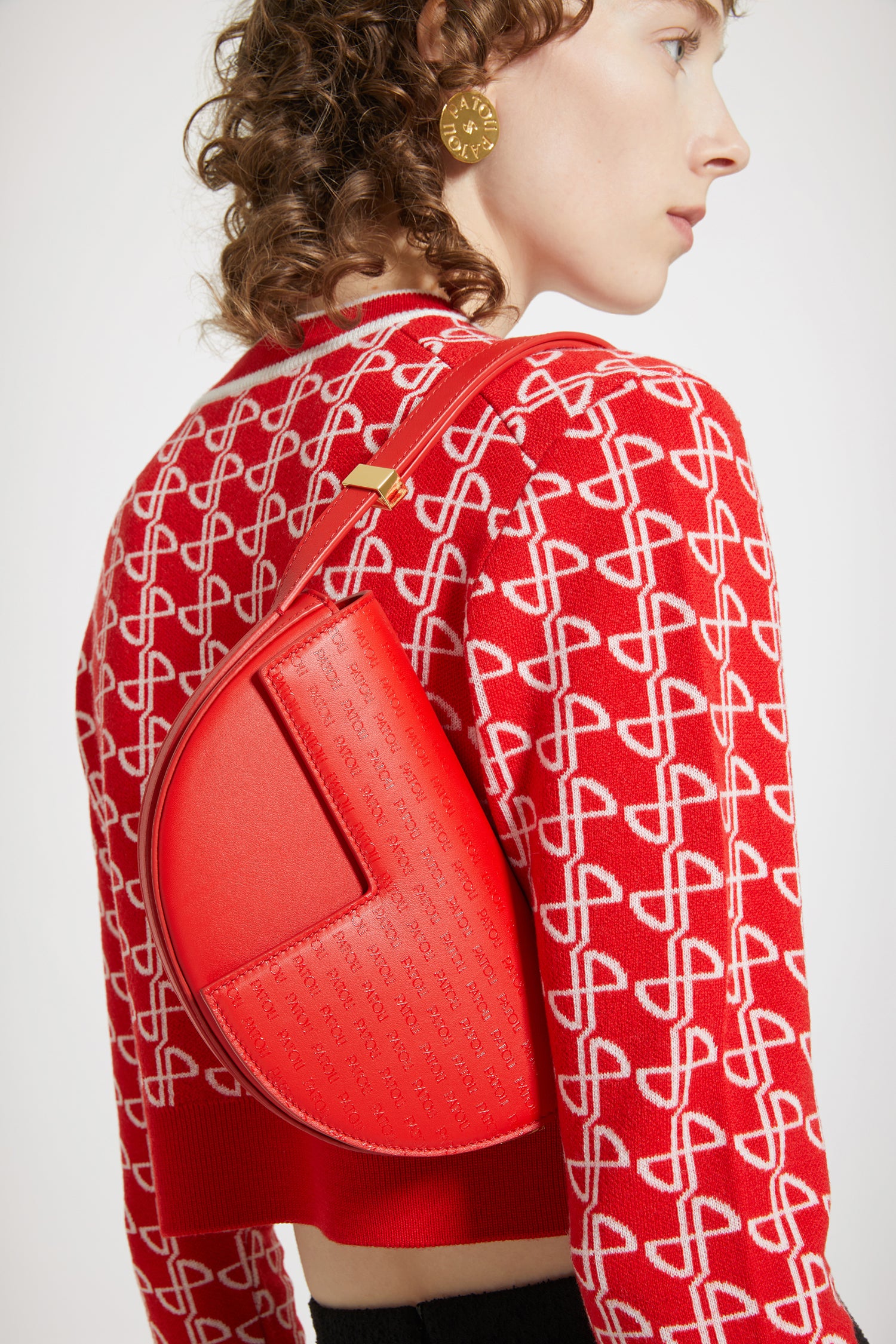 Patou - Borsa Le Petit Patou - Red JP Link - Petit Patou, grande stile.Borsa in pelle rossa. Stampa Patou allover sul risvolto e sul retro. Realizzata con pellami recuperati dal ciclo di produzione. Edizione limitata e numerata di 20 esemplari. Forma a mezzaluna con tagli geometrici ispirati al monogramma JP. Dettaglio in metallo oro inciso Patou al lato. Tracolla regolabile che permette di indossarla in più modi: in spalla, crossbody o a mano. Chiusura magnetica con dettaglio JP oro. Fodera eco-friendly.Dimensioni : lunghezza: 20 cm; altezza: 13 cm; larghezza: 5 cm