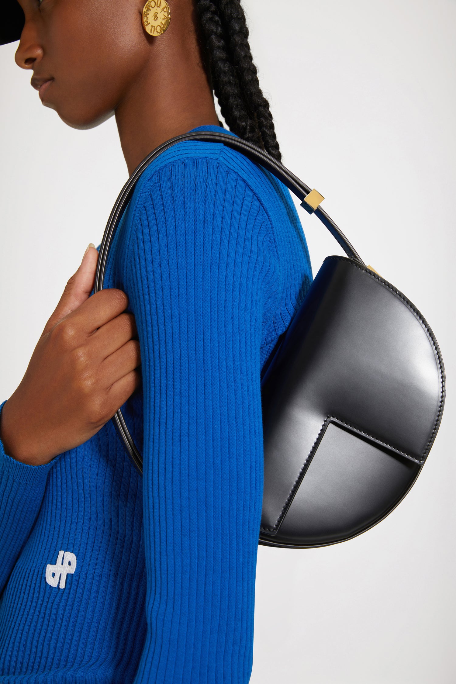 Patou - Le Petit Patou bag in leather - Black - A smaller take on everyone's favourite piece of Patou!Black leather handbag. Crafted using unique materials sourced from unused high-quality leather hides. 80 limited numbered edition. Half-circle shape with geometric cut-outs inspired by the JP monogram. Gold-tone hardware with Patou-engraved detail at the side. Adjustable strap that allows it to be worn on the shoulder, across the body or carried by hand. Magnetic closure with gold-tone JP detail. Internal compartment. Eco lining.Measures: 20cm (length), 13cm (height), 5cm (depth)