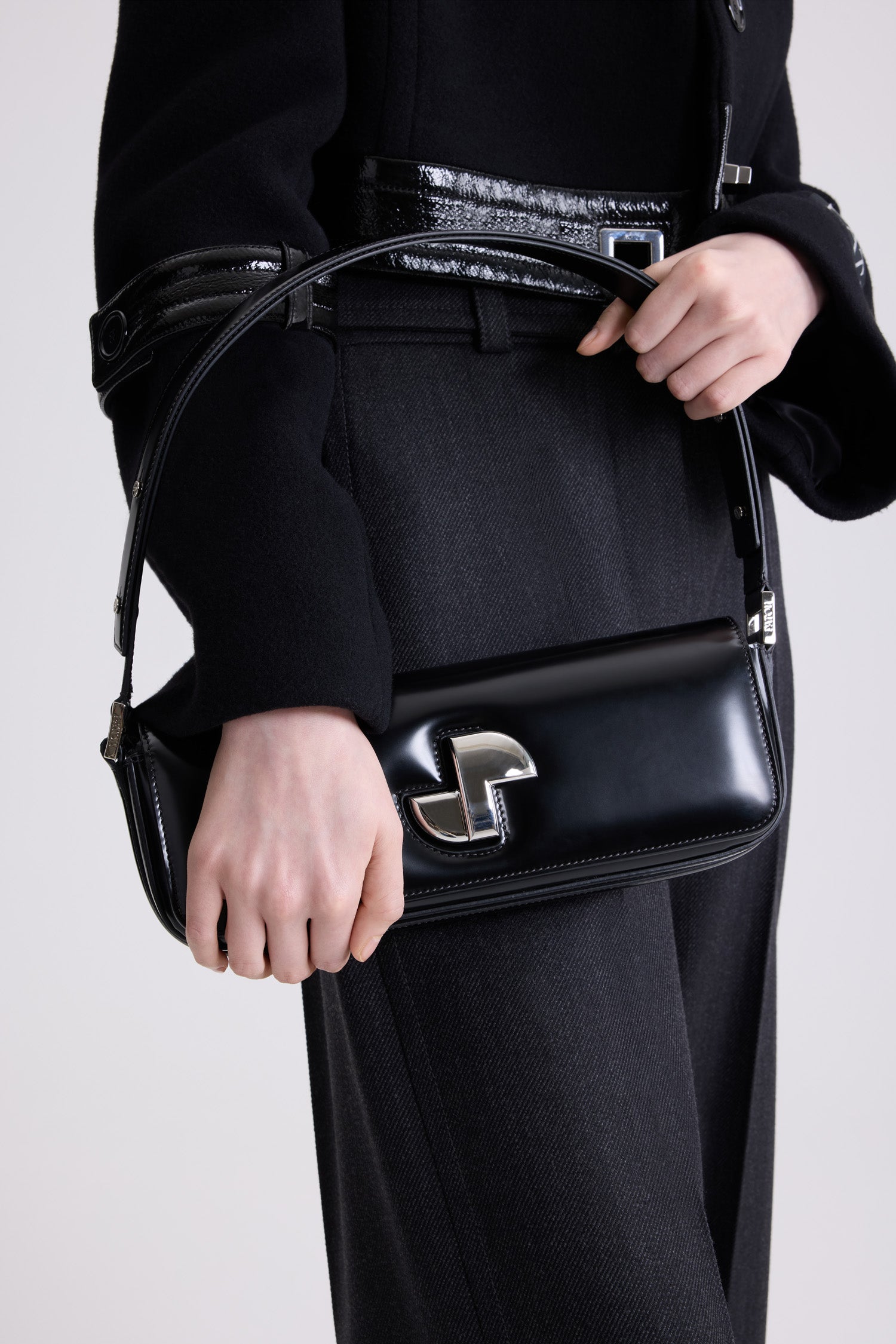 Patou - Le Lock Baguette en cuir - Black - Sac en cuir brillant noir. Sac de jour classique revisité. Forme allongée. Fermoir rotatif JP argenté d'inspiration Art Déco sur le devant. Bandoulière réglable pouvant être portée courte ou longue. Doublure en cuir.