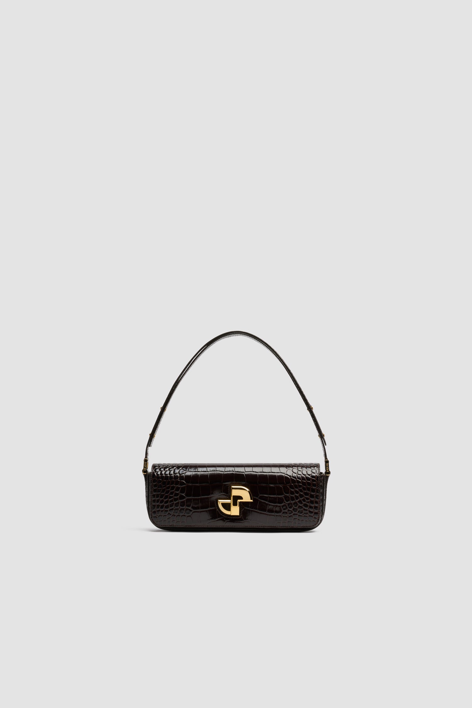 Patou - Borsa Le Lock Baguette in pelle di coccodrillo goffrata - Smoked Ebony - Borsa in pelle di coccodrillo goffrata Smoked Ebony. Borsa da giorno classica rivisitata con una forma allungata. Fermaglio girevole JP oro in stile Art Déco sul davanti. Tracolla regolabile che può essere indossata lunga o corta. Fodera in pelle.