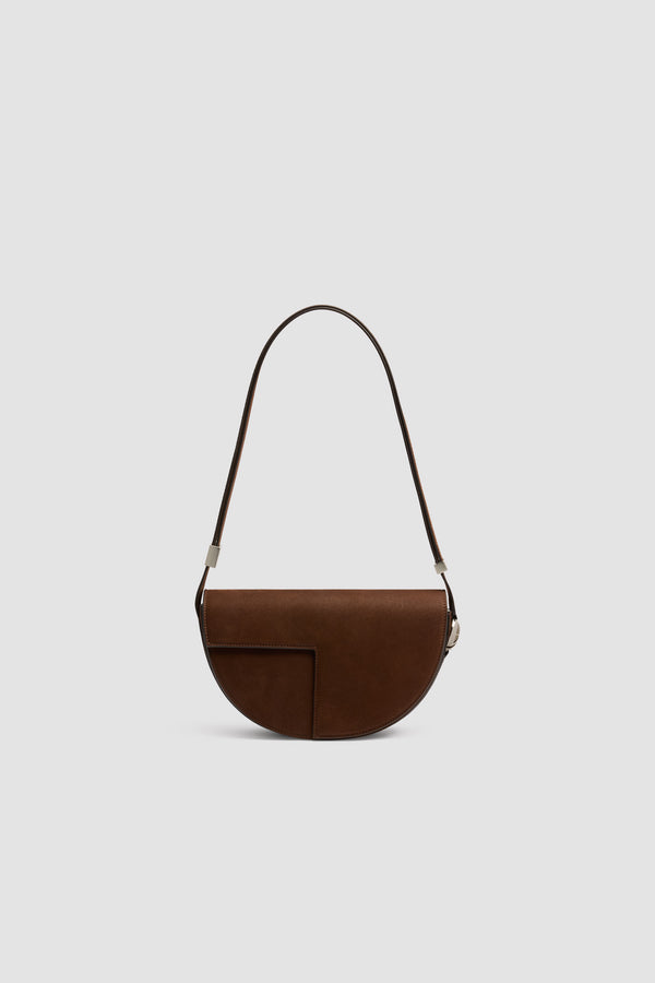 Patou - Sac Le Patou en nubuck - Smoked Ebony - Sac à main en nubuck couleur ébène fumé. Forme demi-lune avec découpes géométriques inspirée du monogramme JP. Pièce en métal doré avec détail JP sur le côté. Bandoulière ajustable permettant un porté épaule, en bandoulière ou à la main. Fermeture aimantée avec détail JP doré. Compartiments multiples à l’intérieur.Dimensions : 25 cm de longueur, 15 cm de hauteur et 6 cm de profondeurBandoulière ajustable en 3 longueurs : 47 cm (porté épaule), 36 cm (porté en bandoulière), 28 cm (porté à la main)