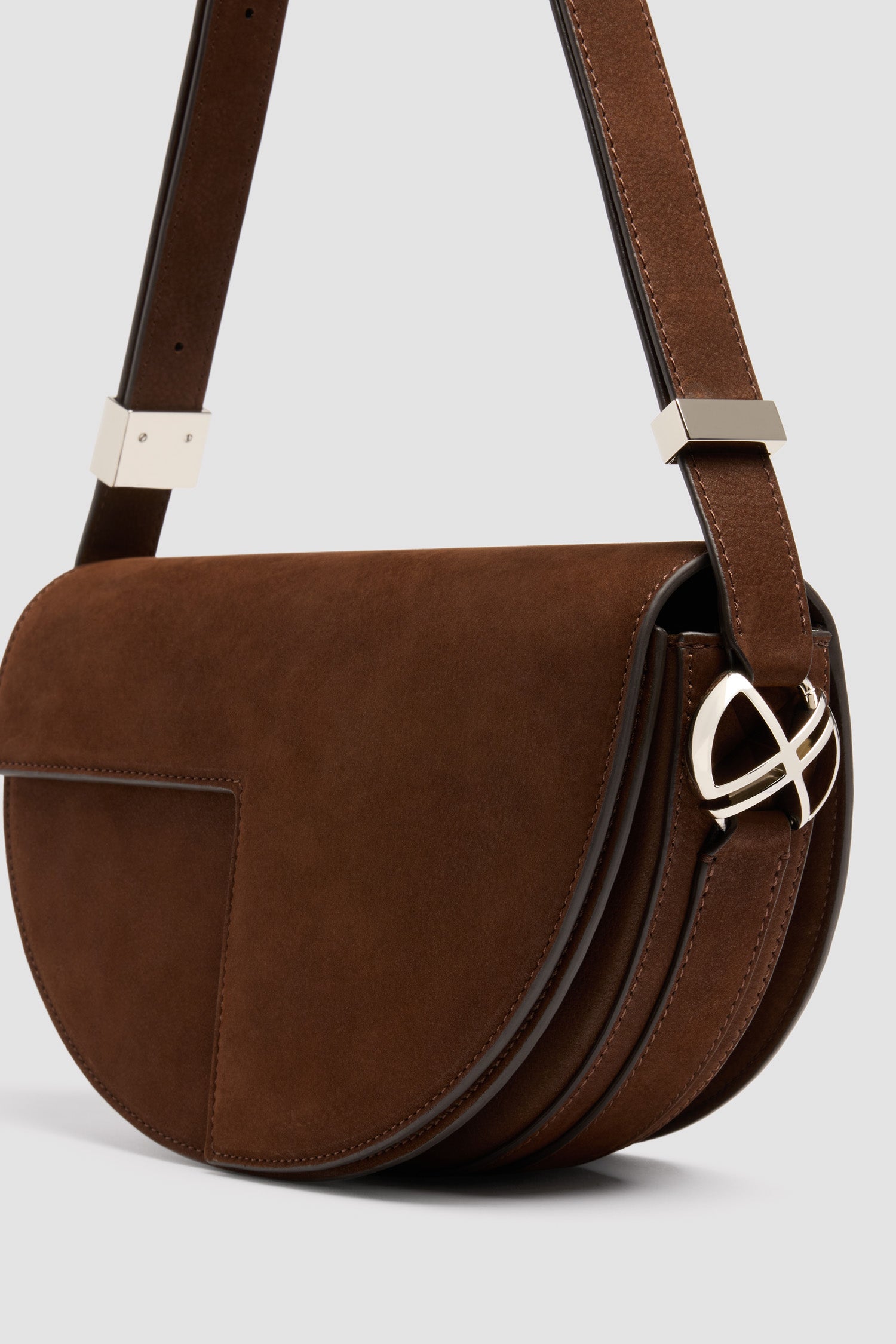 Patou - Sac Le Patou en nubuck - Smoked Ebony - Sac à main en nubuck couleur ébène fumé. Forme demi-lune avec découpes géométriques inspirée du monogramme JP. Pièce en métal doré avec détail JP sur le côté. Bandoulière ajustable permettant un porté épaule, en bandoulière ou à la main. Fermeture aimantée avec détail JP doré. Compartiments multiples à l’intérieur.Dimensions : 25 cm de longueur, 15 cm de hauteur et 6 cm de profondeurBandoulière ajustable en 3 longueurs : 47 cm (porté épaule), 36 cm (porté en bandoulière), 28 cm (porté à la main)