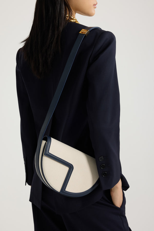 Patou - Le Patou bag in leather and canvas - Navy Black - Navy Black leather and natural cotton canvas handbag. Half-circle shape with geometric cut-outs inspired by the JP monogram. Gold-tone hardware with JP monogram detail at the side. Adjustable strap that allows it to be worn on the shoulder, across the body or carried by hand. Magnetic closure with gold-tone JP detail. Multiple compartments inside.Measures: 25 cm (length), 15 cm (height), 6 cm (depth)3 lengths for the adjustable strap: 47 cm (on the shoulder), 36 cm (across the body), 28 cm (carried by hand)