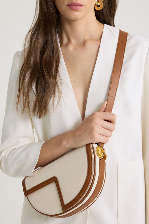 Patou - Le Patou bag in leather and canvas - Caramel - Caramel leather and natural cotton canvas handbag. Half-circle shape with geometric cut-outs inspired by the JP monogram. Gold-tone hardware with JP monogram detail at the side. Adjustable strap that allows it to be worn on the shoulder, across the body or carried by hand. Magnetic closure with gold-tone JP detail. Multiple compartments inside.Measures: 25 cm (length), 15 cm (height), 6 cm (depth)3 lengths for the adjustable strap: 47 cm (on the shoulder), 36 cm (across the body), 28 cm (carried by hand)