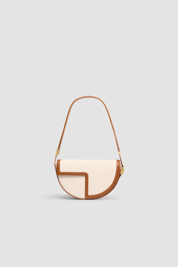 Patou - Le Patou bag in leather and canvas - Caramel - Caramel leather and natural cotton canvas handbag. Half-circle shape with geometric cut-outs inspired by the JP monogram. Gold-tone hardware with JP monogram detail at the side. Adjustable strap that allows it to be worn on the shoulder, across the body or carried by hand. Magnetic closure with gold-tone JP detail. Multiple compartments inside.Measures: 25 cm (length), 15 cm (height), 6 cm (depth)3 lengths for the adjustable strap: 47 cm (on the shoulder), 36 cm (across the body), 28 cm (carried by hand)