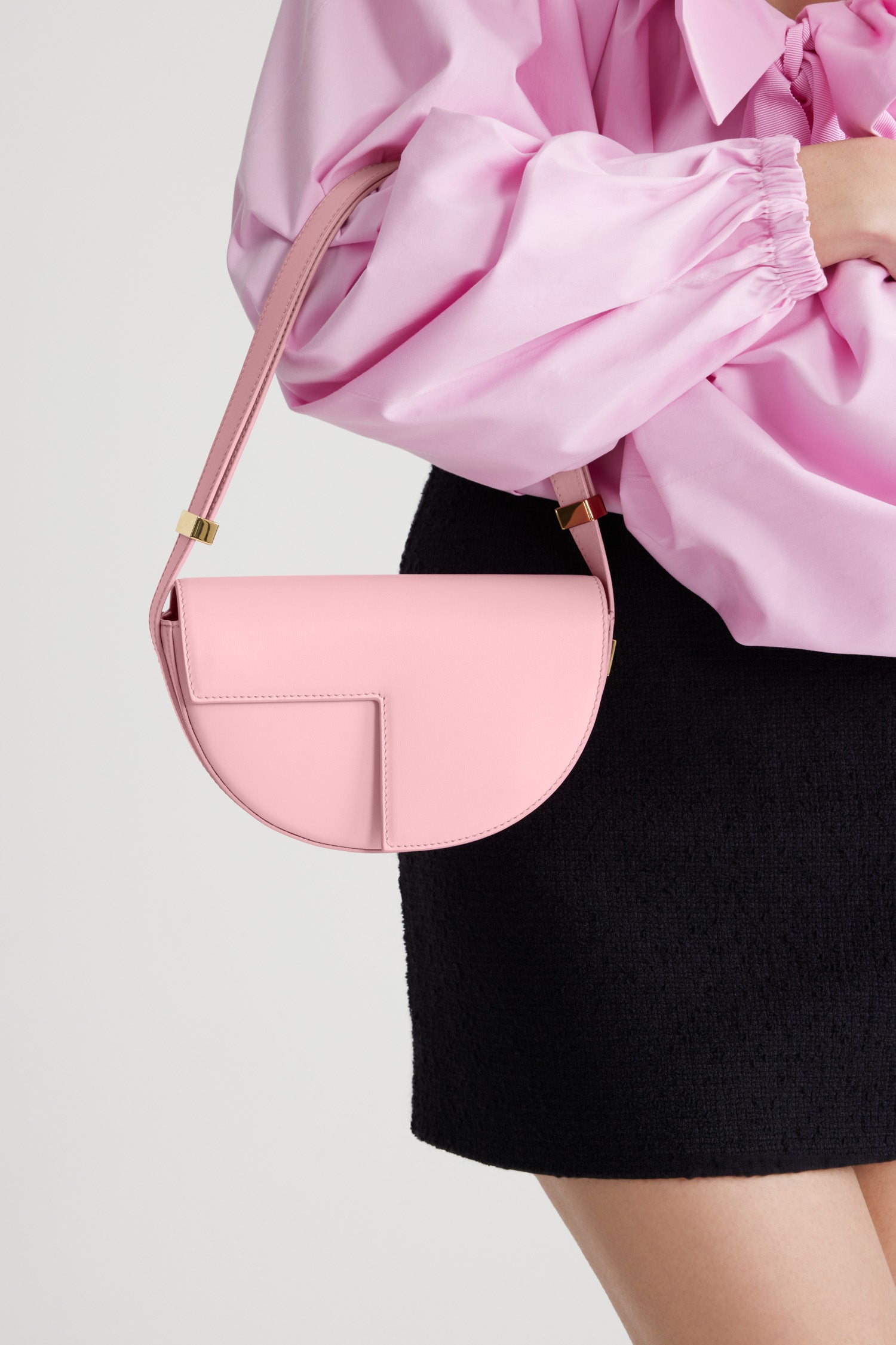Patou - Borsa Le Petit Patou in pelle - Rosebloom Pink - Borsa in pelle rosa. Forma a mezzaluna con tagli geometrici ispirati al monogramma JP. Dettaglio in metallo oro inciso Patou al lato. Tracolla regolabile che permette di indossarla in più modi: in spalla, crossbody o a mano. Chiusura magnetica con dettaglio JP oro. Fodera ecosostenibile.Dimensioni : lunghezza: 20 cm; altezza: 13 cm; larghezza: 5 cm
