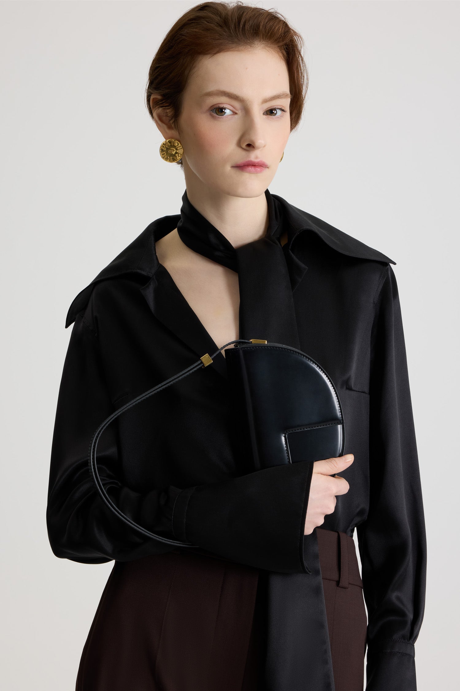 Patou - Le Petit Patou bag in leather - Black - Black leather handbag. Half-circle shape with geometric cut-outs inspired by the JP monogram. Gold-tone hardware with Patou-engraved detail at the side. Adjustable strap that allows it to be worn on the shoulder, across the body or carried by hand. Magnetic closure with gold-tone JP detail. Internal compartment. Eco lining.Measures: 20cm (length), 13cm (height), 5cm (depth)