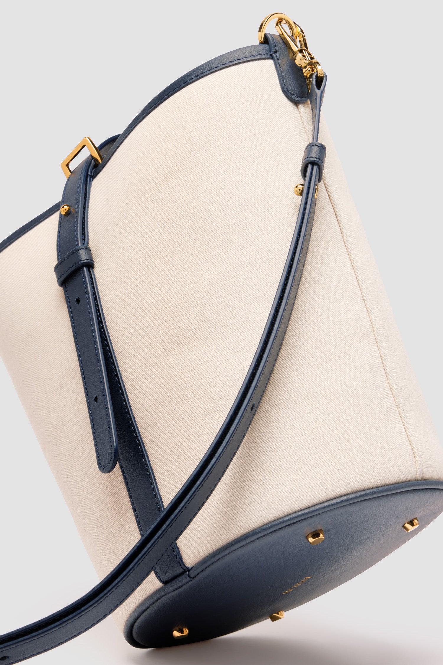 Patou - Borsa a secchiello JP media in pelle e cotone - Navy Black - Borsa in pelle blu nero e cotone naturale. Realizzata con pellami recuperati dal ciclo di produzione. Modello medio. Forma a secchiello con monogramma JP in 3D sul davanti. Chiusura con cinghia. Tracolla rimovibile e regolabile. Parti metalliche oro. Piedini in metallo. Logo Patou oro sulla base.