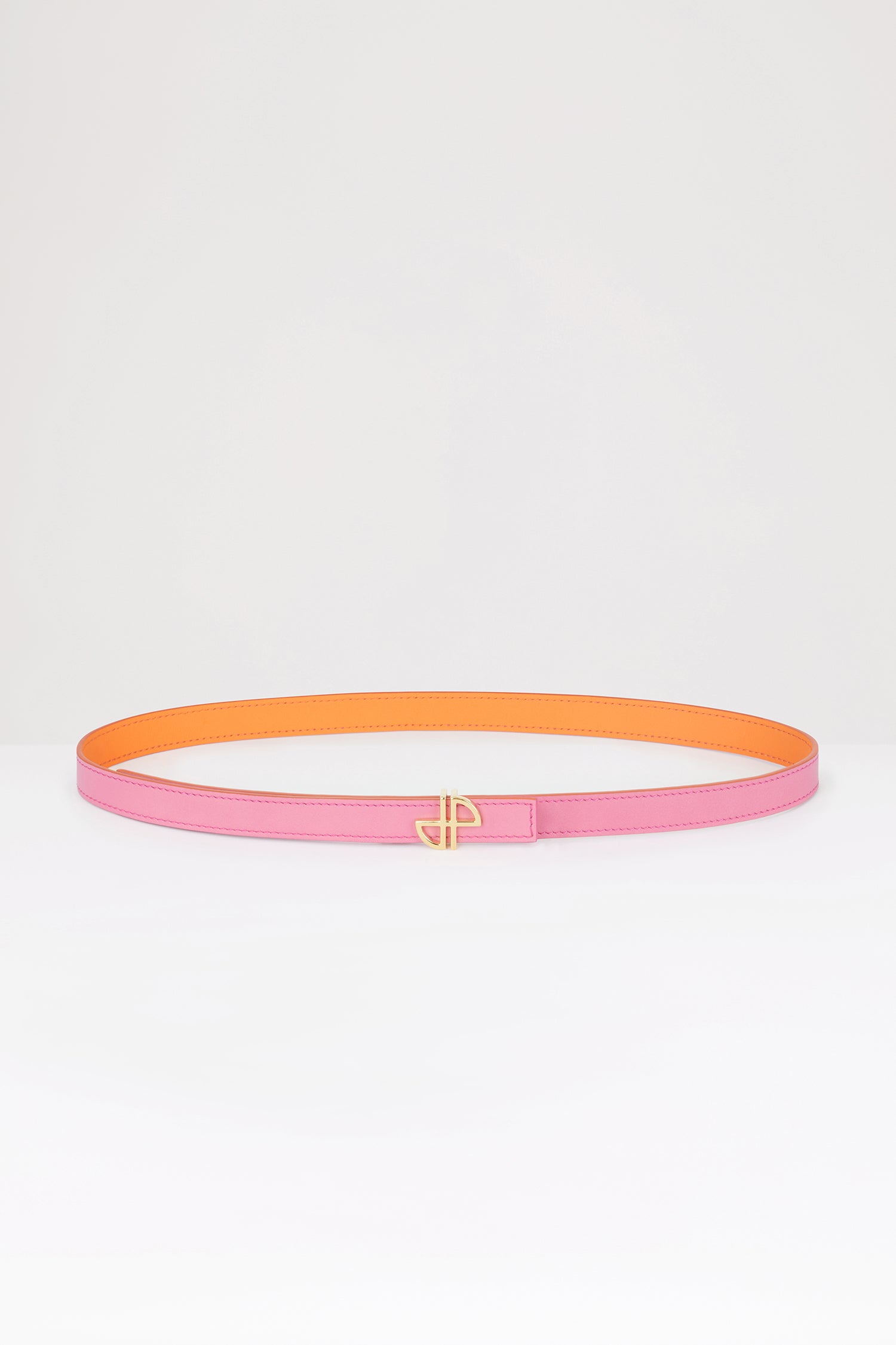 Patou - 細めのレザー製JP ベルト - Bright Orange - JPの美学を落とし込んだデザイン。ブライトオレンジのレザーベルト。未使用の高品質皮革を用いた独自素材を一部使用。リバーシブル仕様。細めのデザイン。ゴールドトーンのJPバックル。調整可能なデザイン。プッシュスタッド留め。Sサイズ(最長):85cm Mサイズ(最長):90cm Lサイズ(最長):100cm