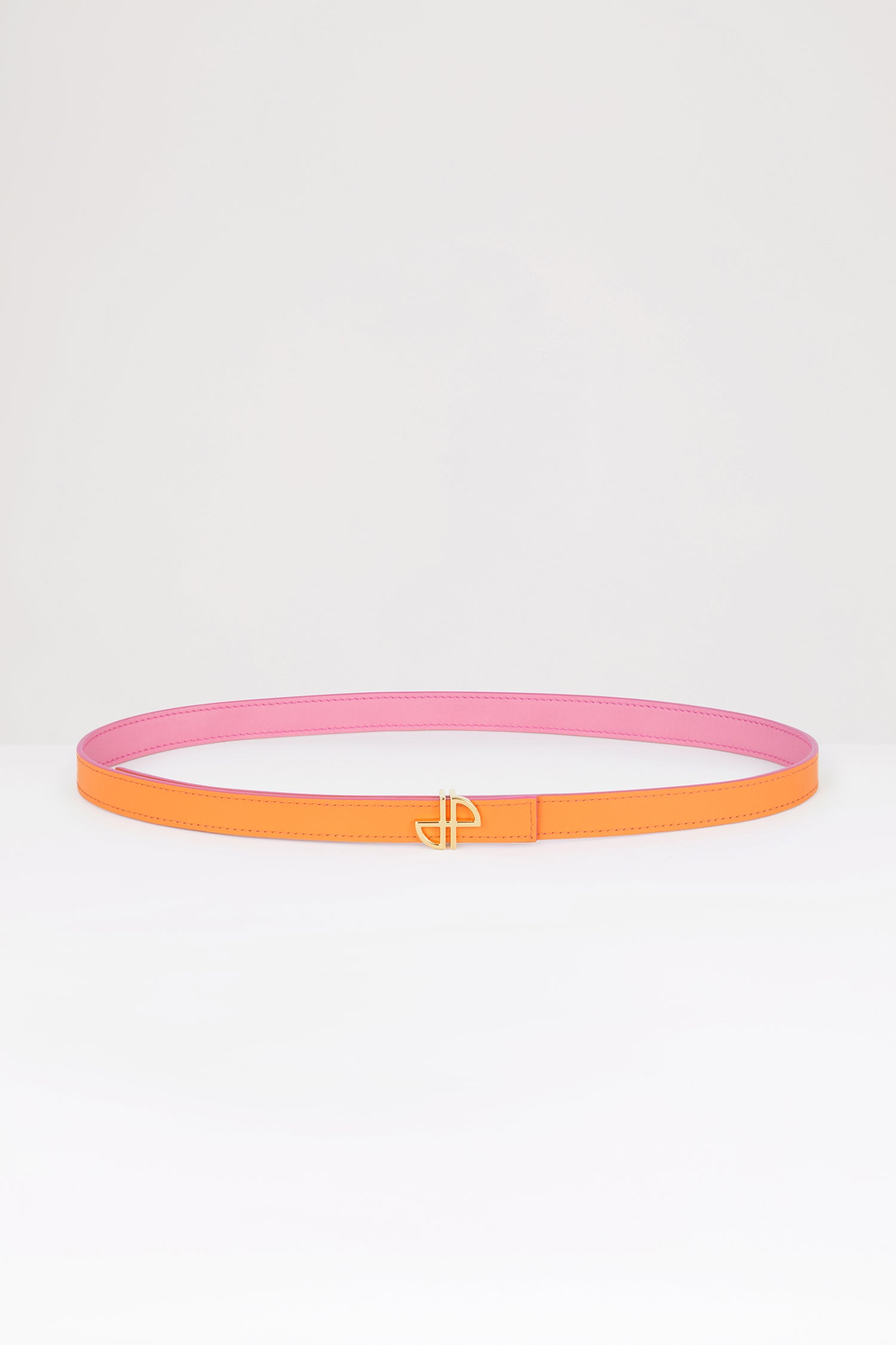 Patou - 細めのレザー製JP ベルト - Bright Orange - JPの美学を落とし込んだデザイン。ブライトオレンジのレザーベルト。未使用の高品質皮革を用いた独自素材を一部使用。リバーシブル仕様。細めのデザイン。ゴールドトーンのJPバックル。調整可能なデザイン。プッシュスタッド留め。Sサイズ(最長):85cm Mサイズ(最長):90cm Lサイズ(最長):100cm