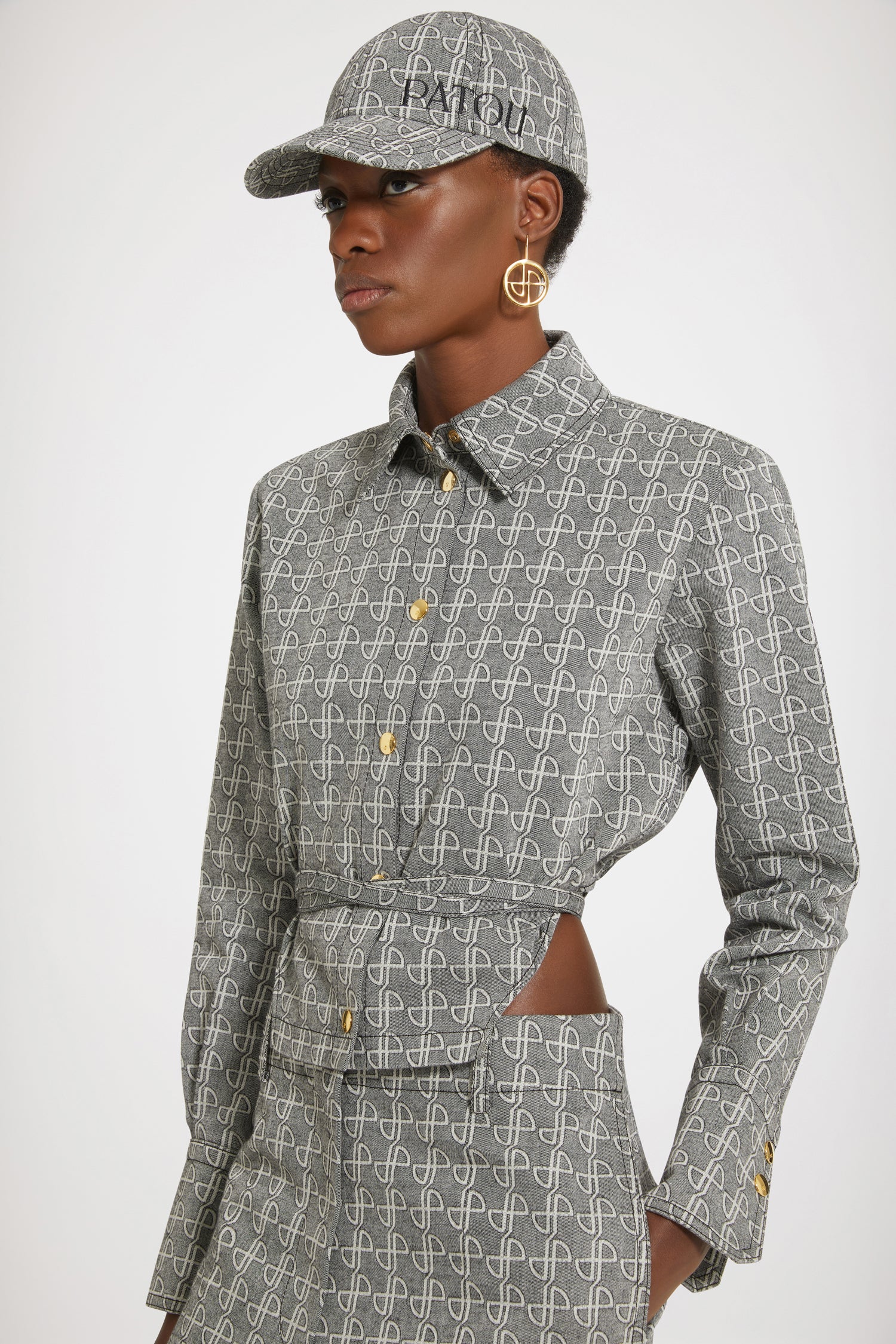 Patou - Cut-out cropped shirt in cotton jacquard - Black JP link - A new silhouette that hits all the right notes.Black and white cotton jacquard. Allover JP pattern. Cropped silhouette with violin-shaped cut-outs at the sides. Gold-tone press buttons at the front and cuffs. Belt at the waist with tunnel at the back. Pleating at the cuffs.