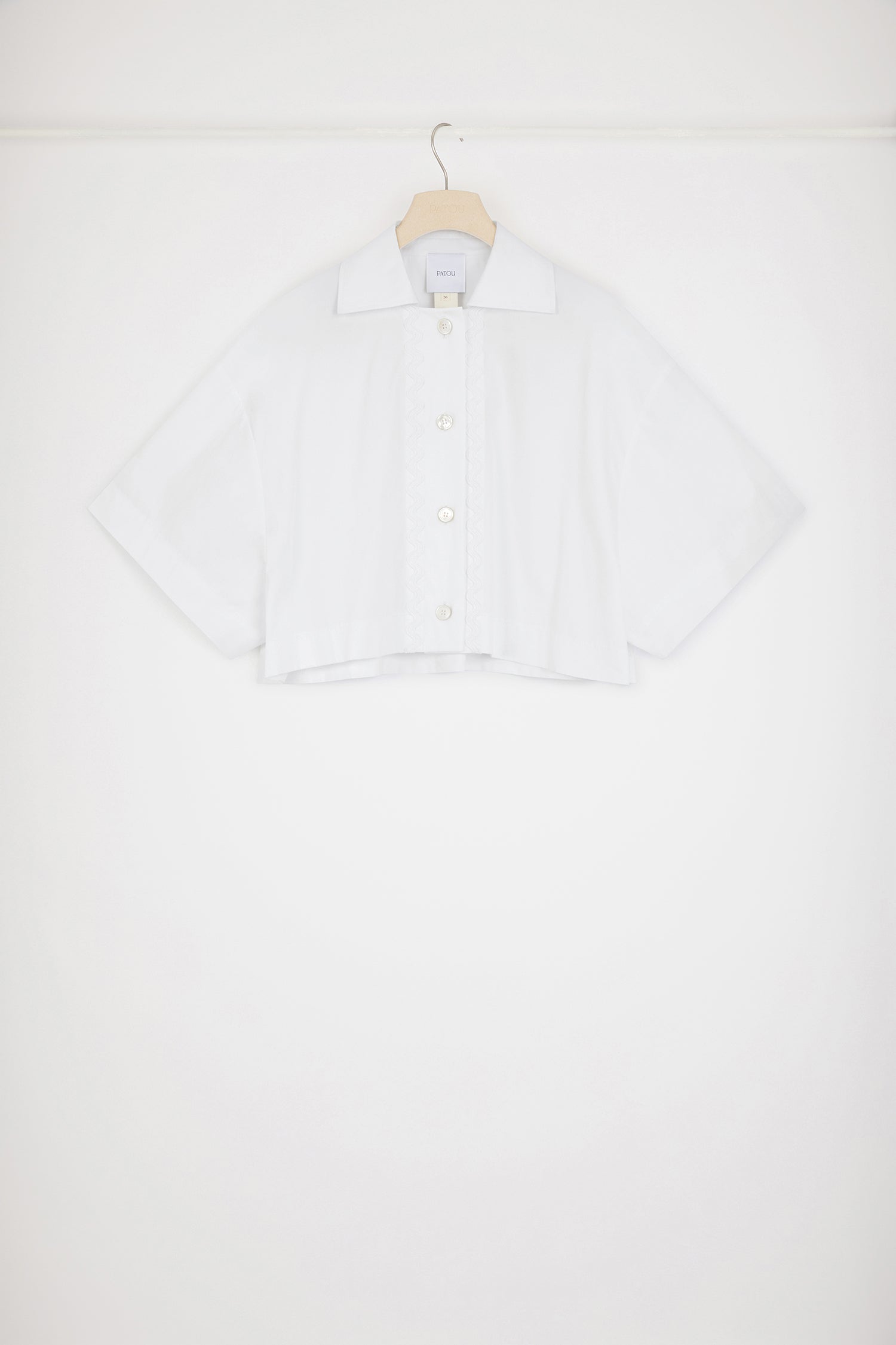 Patou - Camicia corta a onde in cotone ecosostenibile - White - L'arte sottile del dettaglio.Camicia in popeline di cotone ecosostenibile bianca. Modello corto e largo. Collo classico. Bottoni incisi JP. Decorazione a onde sul davanti.Questo modello oversize ha una vestibilità corta e larga.