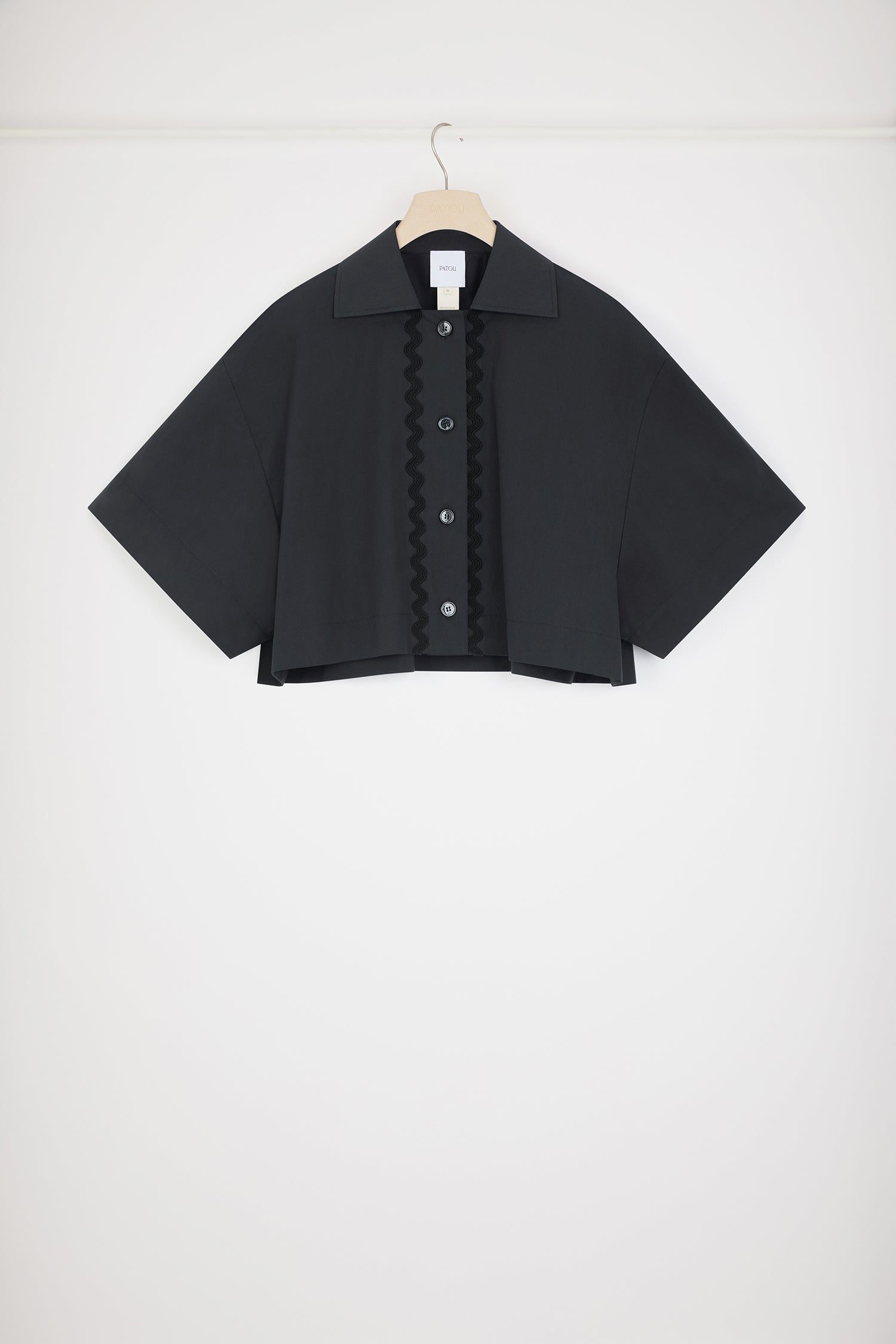 Patou - Wave cropped shirt in sustainable cotton - Black - The art of the subtle embellishment.Black sustainable cotton poplin blouse. Boxy fit. Cropped length. Shirt collar. JP-engraved buttons. Wave trims down the front.This oversized style was designed for a cropped and wide fit.
