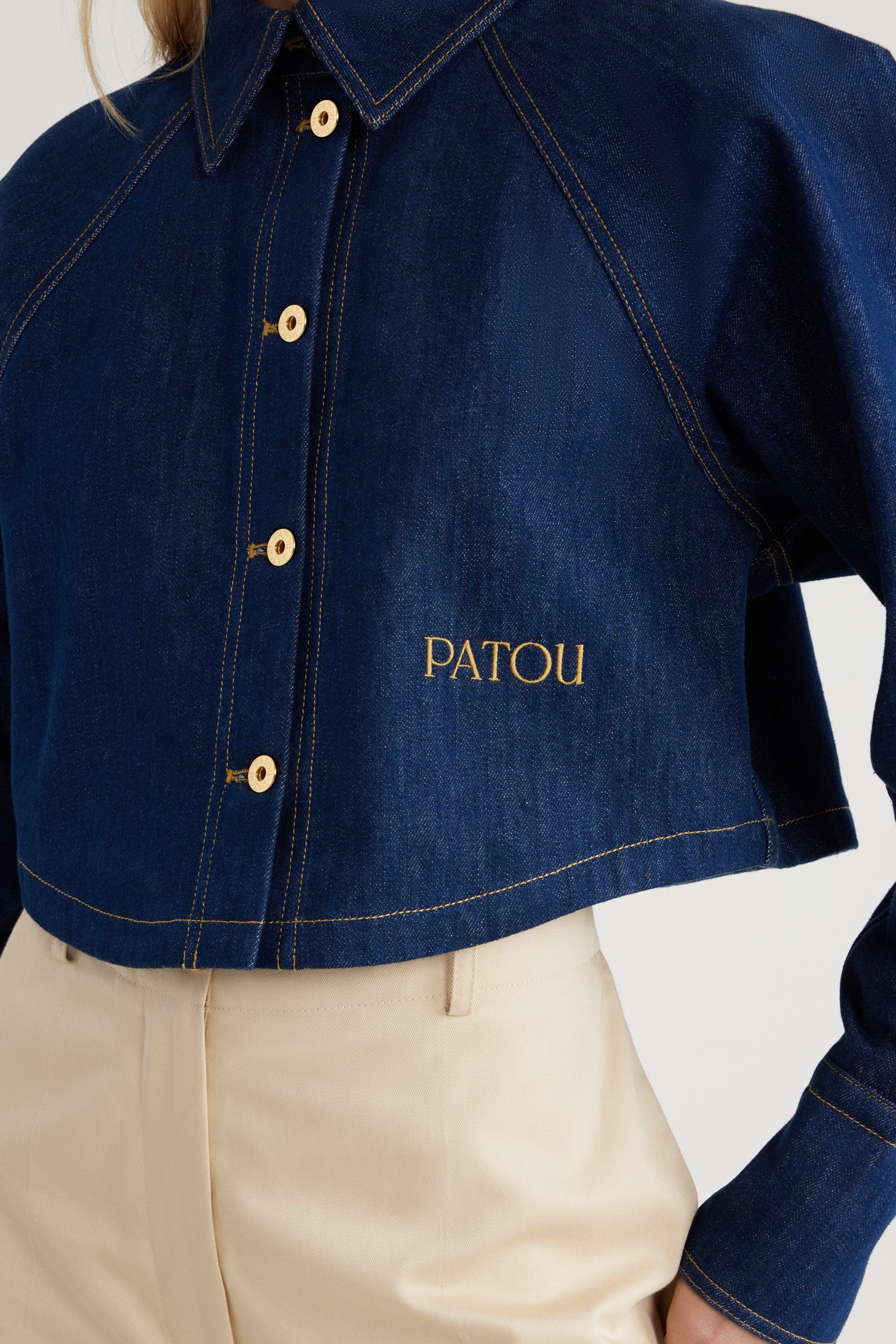 Patou - Kurzes Hemd aus Bio-Baumwolldenim - Rodeo Blue - Jeanshemd in Rodeo Blue aus Bio-Baumwolldenim. Gekürzte Länge. Hemdkragen mit JP-Monogramm auf der Innenseite. Goldfarbene Knöpfe mit Patou-Gravur. Patou Stickerei vorne. Raglanärmel. Geknöpfte Manschetten. Tabakfarbene Ziernähte.