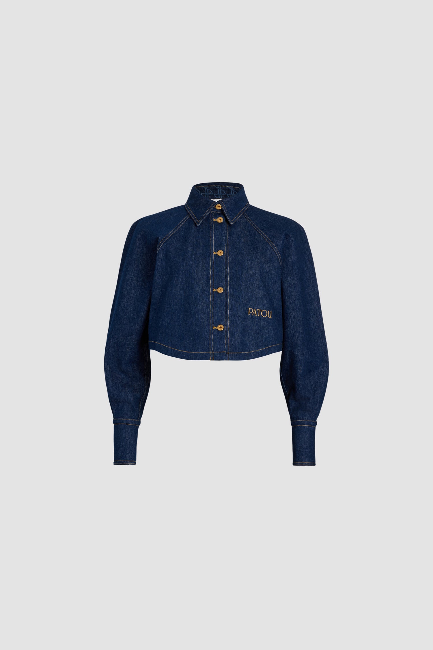 Patou - Kurzes Hemd aus Bio-Baumwolldenim - Rodeo Blue - Jeanshemd in Rodeo Blue aus Bio-Baumwolldenim. Gekürzte Länge. Hemdkragen mit JP-Monogramm auf der Innenseite. Goldfarbene Knöpfe mit Patou-Gravur. Patou Stickerei vorne. Raglanärmel. Geknöpfte Manschetten. Tabakfarbene Ziernähte.