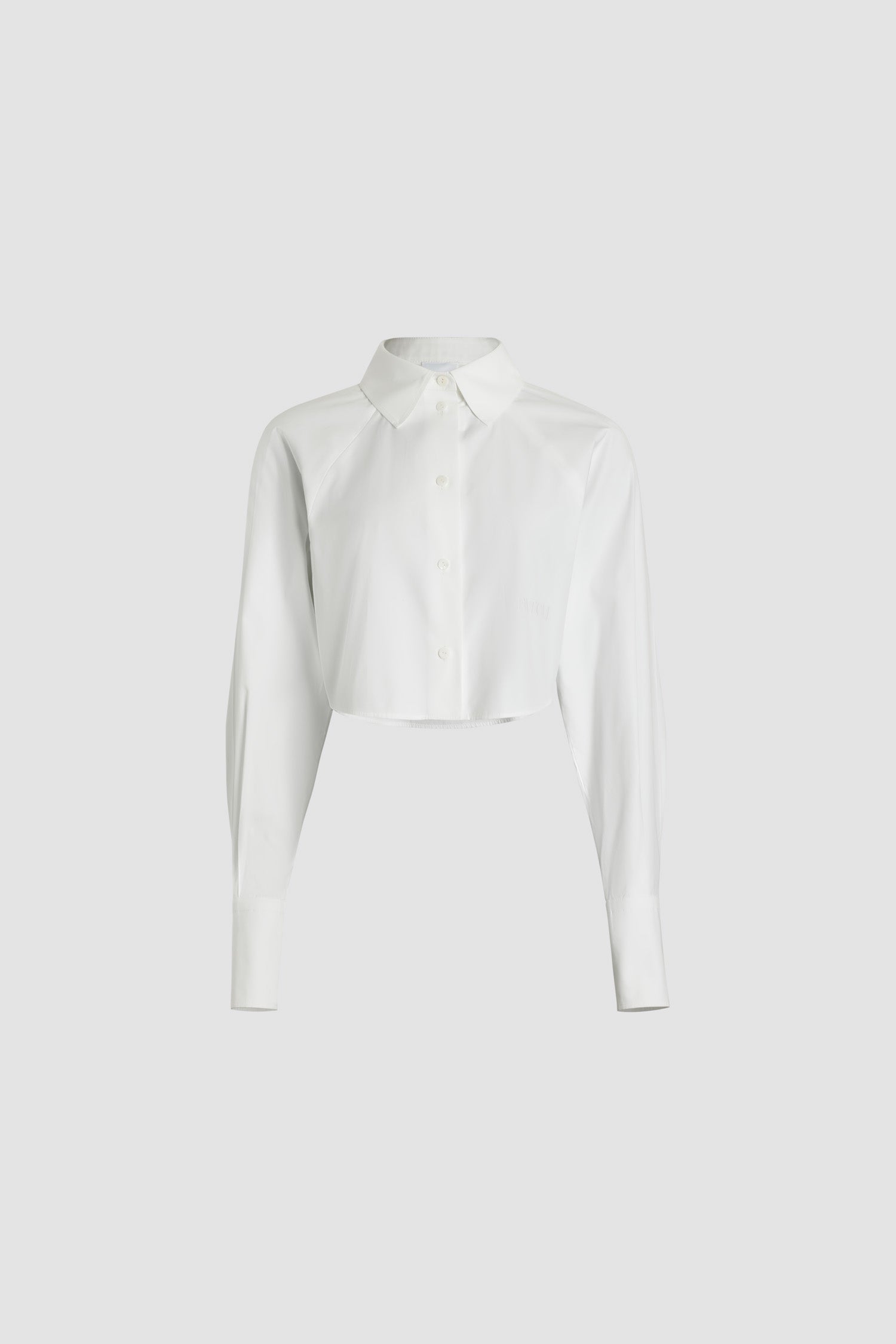 Patou - Chemise courte en coton bio - White - Chemise en coton bio blanc. Modèle court. Col de chemise. Boutons en nacre gravés JP. Patou brodé sur le devant. Manches raglan. Poignets boutonnés.