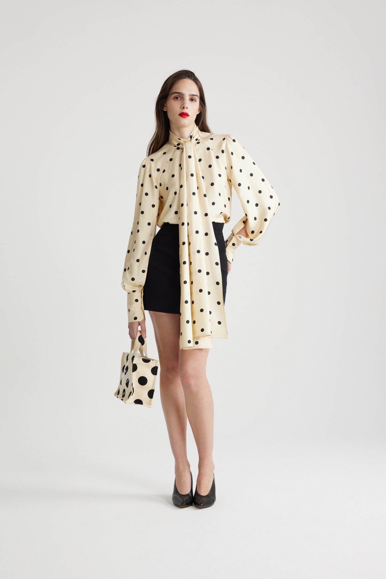 Patou - Lavallière-Bluse aus bedruckter Bio-Seide - Angora Dots - Bluse in Angora Off-White aus Bio-Seide. Gepunkteter Print. Stehkragen mit abnehmbarer Lavallière-Schleife. Perlmuttknöpfe mit JP-Gravur. Voluminöse Raglanärmel mit aufgebauschten Schultern und geknöpften französischen Manschetten.