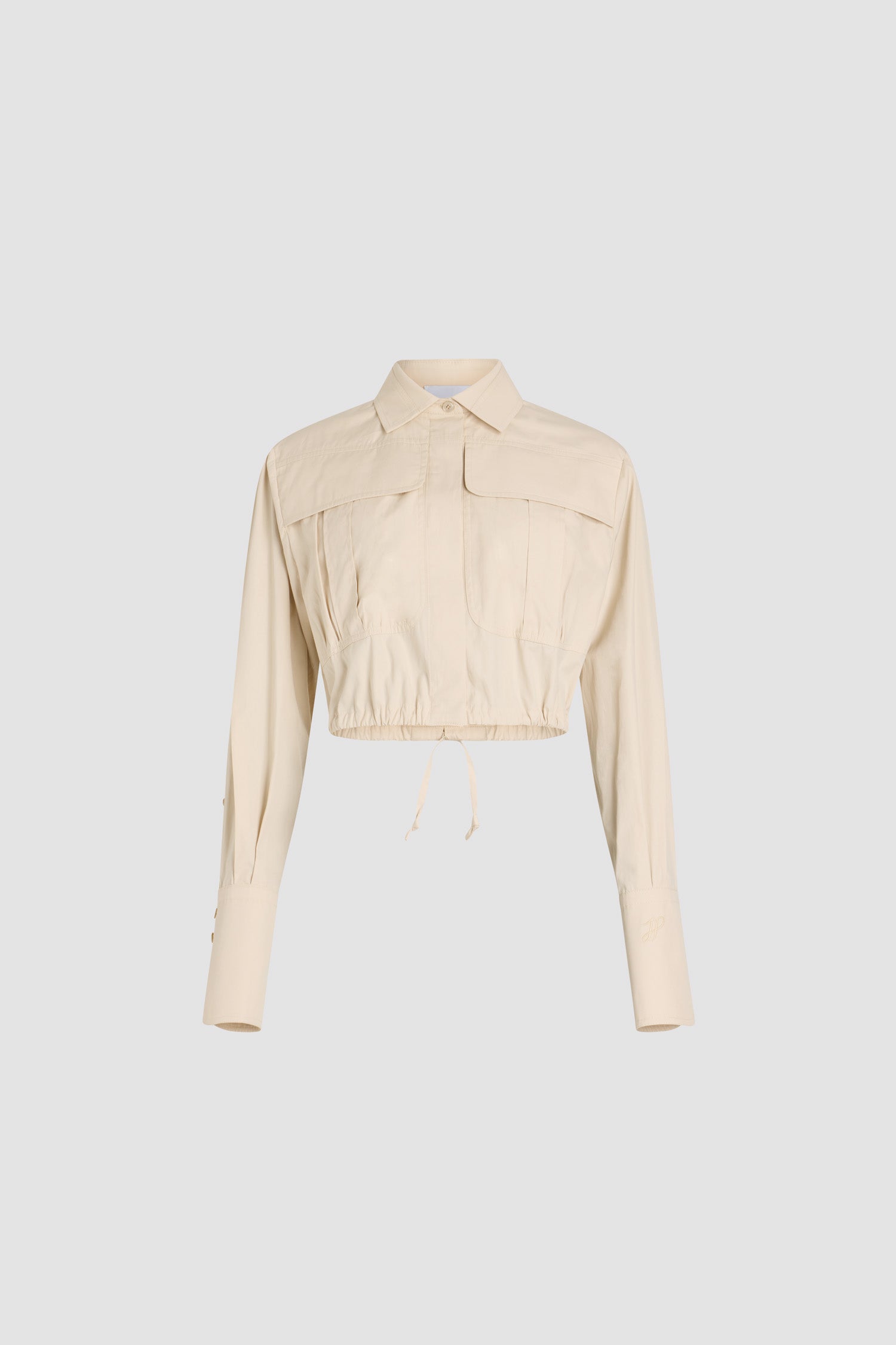 Patou - Camicia safari corta in popeline di cotone bio - Tapioca - Camicia in popeline di cotone bio beige tapioca. Modello corto. Colletto classico. Abbottonatura nascosta. Tasche a toppa alte sul petto. Maniche allungate con polsini abbottonati. Monogramma JP ricamato sulla manica sinistra. Piega sul retro. Vita con coulisse con allacciatura sul retro.