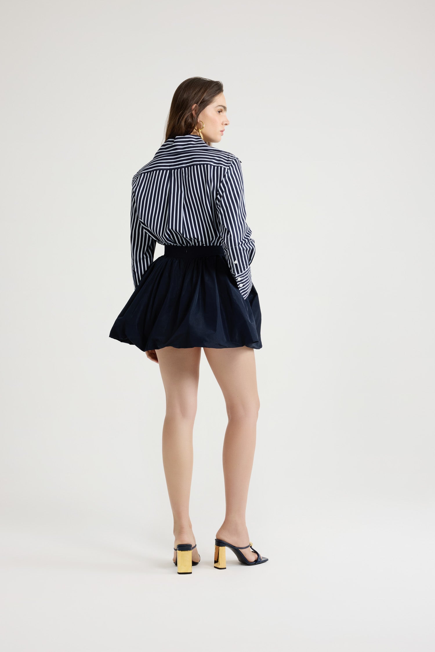 Patou - Camicia aderente in popeline di cotone bio stampato - Navy Stripes - Camicia in popeline di cotone bio blu scuro. Fantasia a righe. Silhouette a forma di violino con vestibilità aderente. Colletto largo. Chiusura con bottoni sul davanti. Polsini abbottonati. Monogramma JP ricamato sul davanti. Orlo asimmetrico più lungo sul retro.