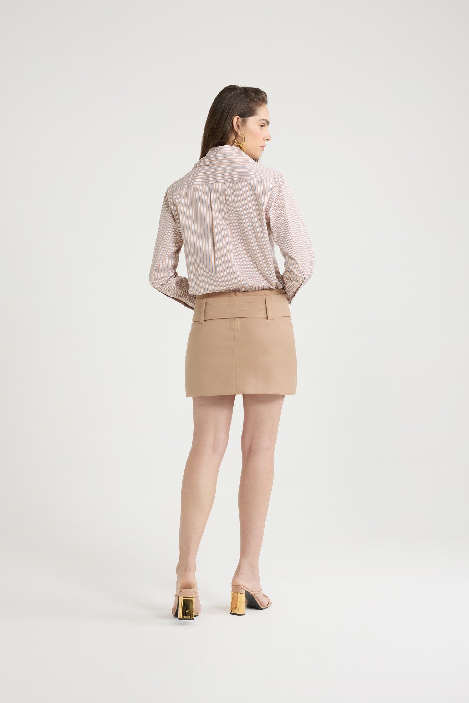 Patou - Camicia aderente in popeline di cotone bio stampato - Beige Stripes - Camicia in popeline di cotone bio beige. Fantasia a righe. Silhouette a forma di violino con vestibilità aderente. Colletto largo. Chiusura con bottoni sul davanti. Polsini abbottonati. Monogramma JP ricamato sul davanti. Orlo asimmetrico più lungo sul retro.