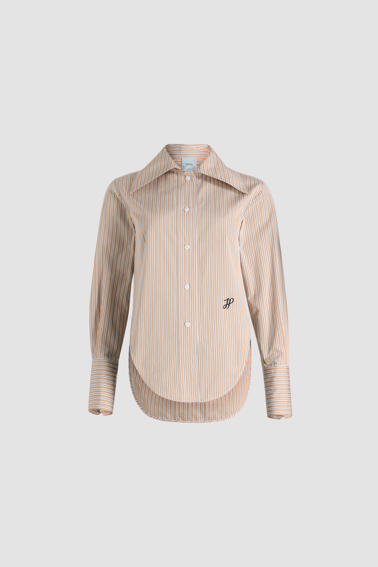 Patou - Camicia aderente in popeline di cotone bio stampato - Beige Stripes - Camicia in popeline di cotone bio beige. Fantasia a righe. Silhouette a forma di violino con vestibilità aderente. Colletto largo. Chiusura con bottoni sul davanti. Polsini abbottonati. Monogramma JP ricamato sul davanti. Orlo asimmetrico più lungo sul retro.