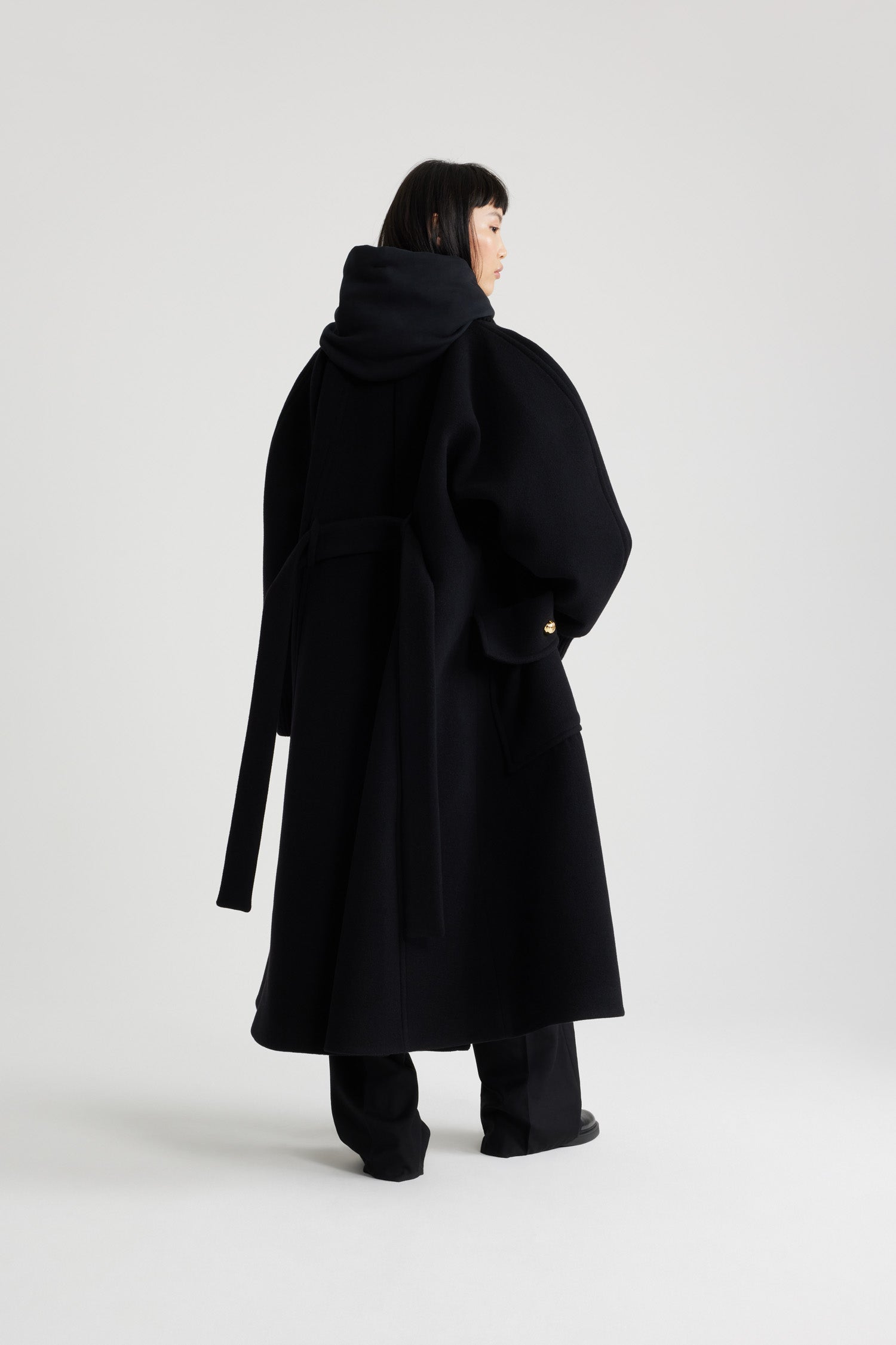 Patou - Oversized coat in wool and cashmere blend - Black - Black wool and cashmere blend coat. Oversized fit. Long length. A-line silhouette. Rib knit collar and cuffs. Raglan sleeves. Gold-tone half-sphere JP buttons. Self-tie belt at the waist. Maxi patch pockets with buttoned flap. Box pleat at the back.This style is oversized.