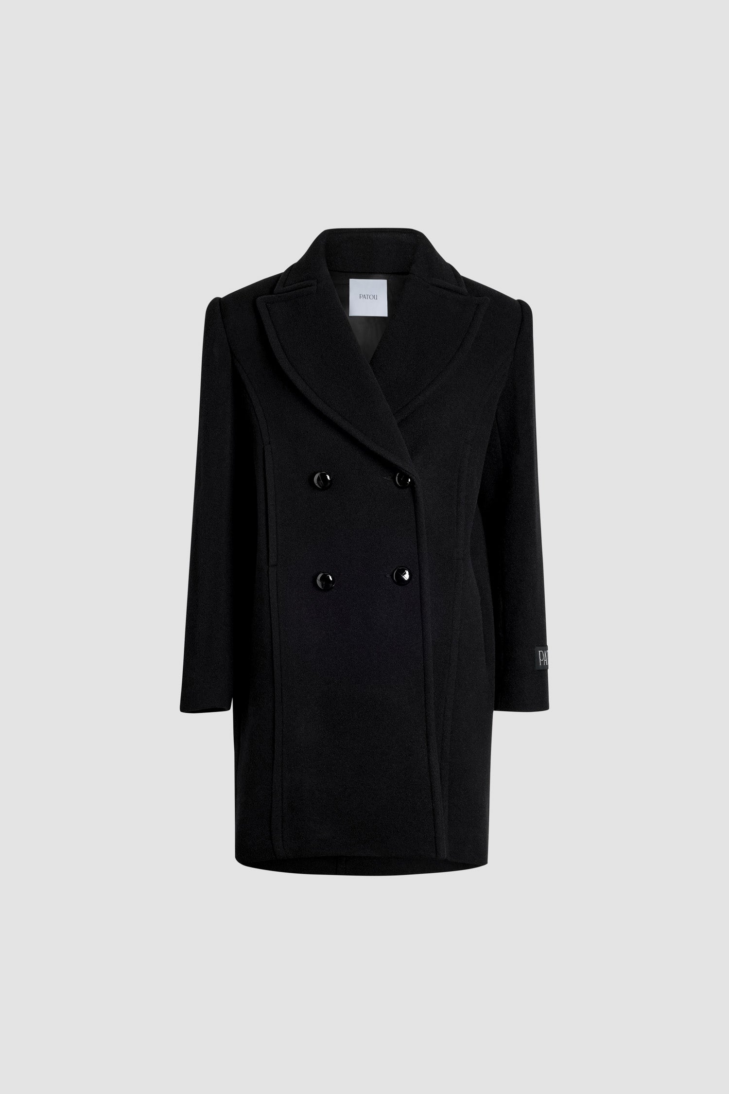 Patou - Zweireihiger Mantel aus Wolle und Kaschmir - Black - Schwarzer Mantel aus Wolle und Kaschmir. Knielang. Gerade Silhouette. Zweireihige Konstruktion. Breites, steigendes Revers. Knöpfe aus gewebtem Leder. Saumtaschen. Geknöpfte Manschetten. Patou Aufnäher auf dem linken Ärmel. Gefüttert.Dieses Modell hat einen geraden Schnitt und weiche Schultern.