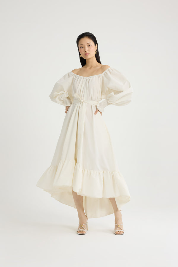 Patou - Robe cocktail longue en faille recyclée - Ivory - Robe en faille recyclée ivoire. Modèle long. Construction à volants. Silhouette asymétrique plus longue au dos. Encolure élastiquée pouvant dévoiler les épaules. Manches volumineuses à poignets smockés. Ceinture à la taille. Poches latérales.Cette robe fait partie de la collection Cérémonie créée pour les occasions spéciales.