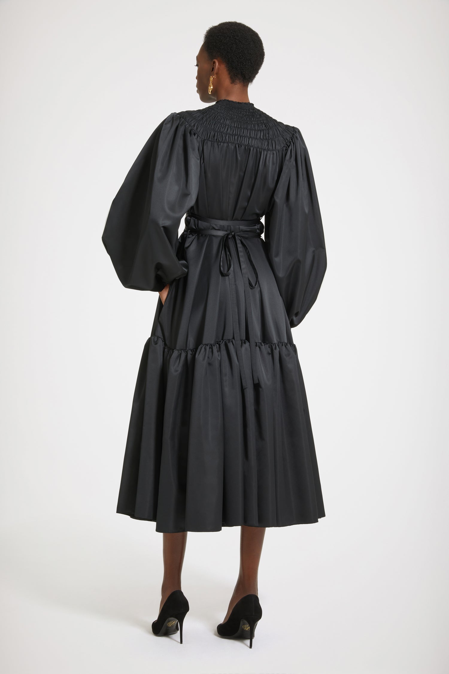 Patou - Smock collar maxi dress in eco-friendly satin - Black - This dress is a total smock show! Black recycled polyester satin dress. Maxi length. High neckline with smocked detailing. Volume sleeves with puff shoulders and elasticated cuffs. Removable belt at the waist that can be tied at the front or back. Tiered skirt.Voluminous dress with puffed sleeves.