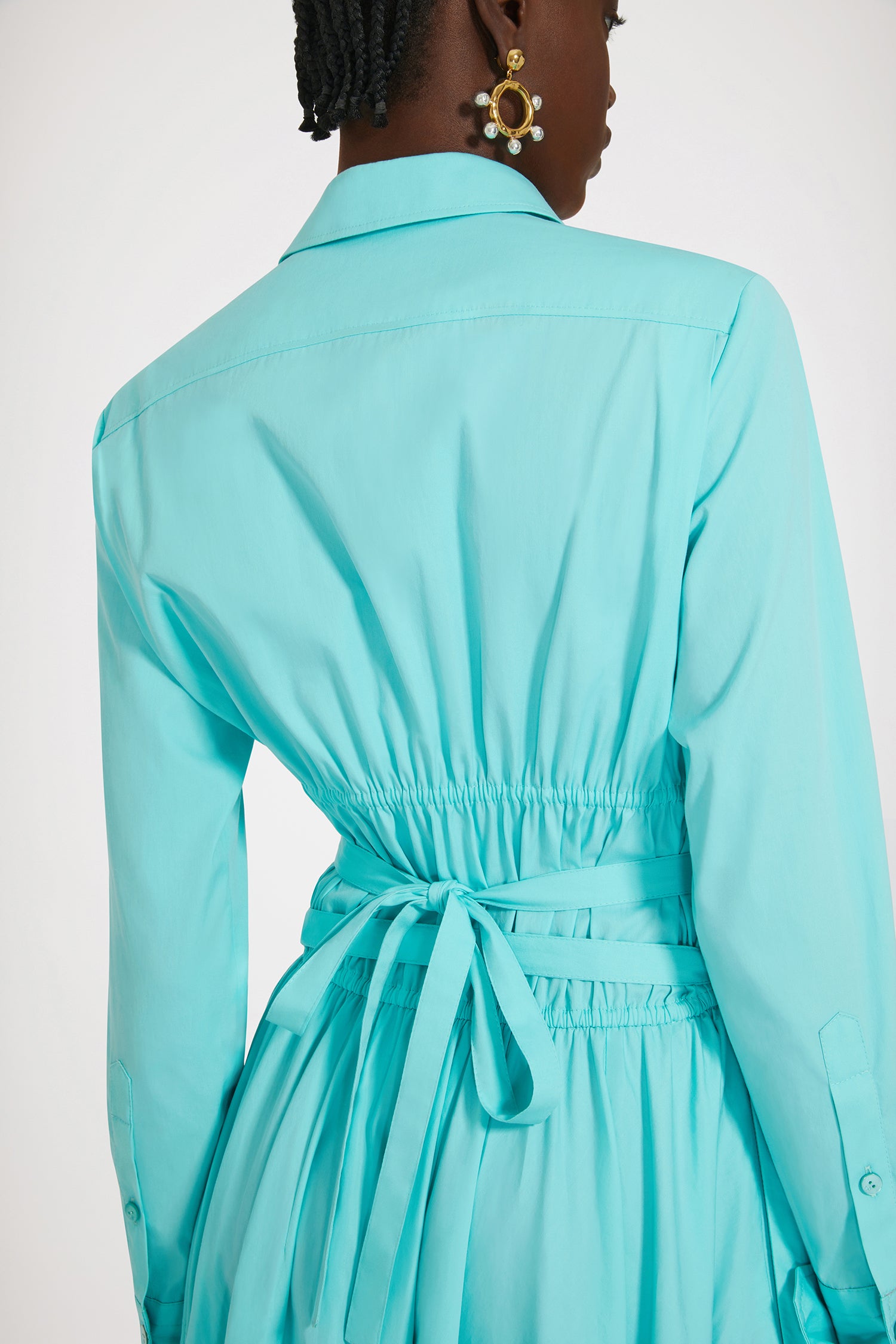 Patou - サステナブルコットン マキシ シャツドレス - Mint Green - 日々のコーデに活躍するパトゥのシャツドレスミントグリーンのサステナブルコットン ポプリンドレス。マキシ丈。シャツカラー。ティアードボディス、コンシールボタン。ウエストに細い布製ベルト。袖口にボタン、左袖にPatou刺繍。ボリューム感のあるスカート。シームポケット。