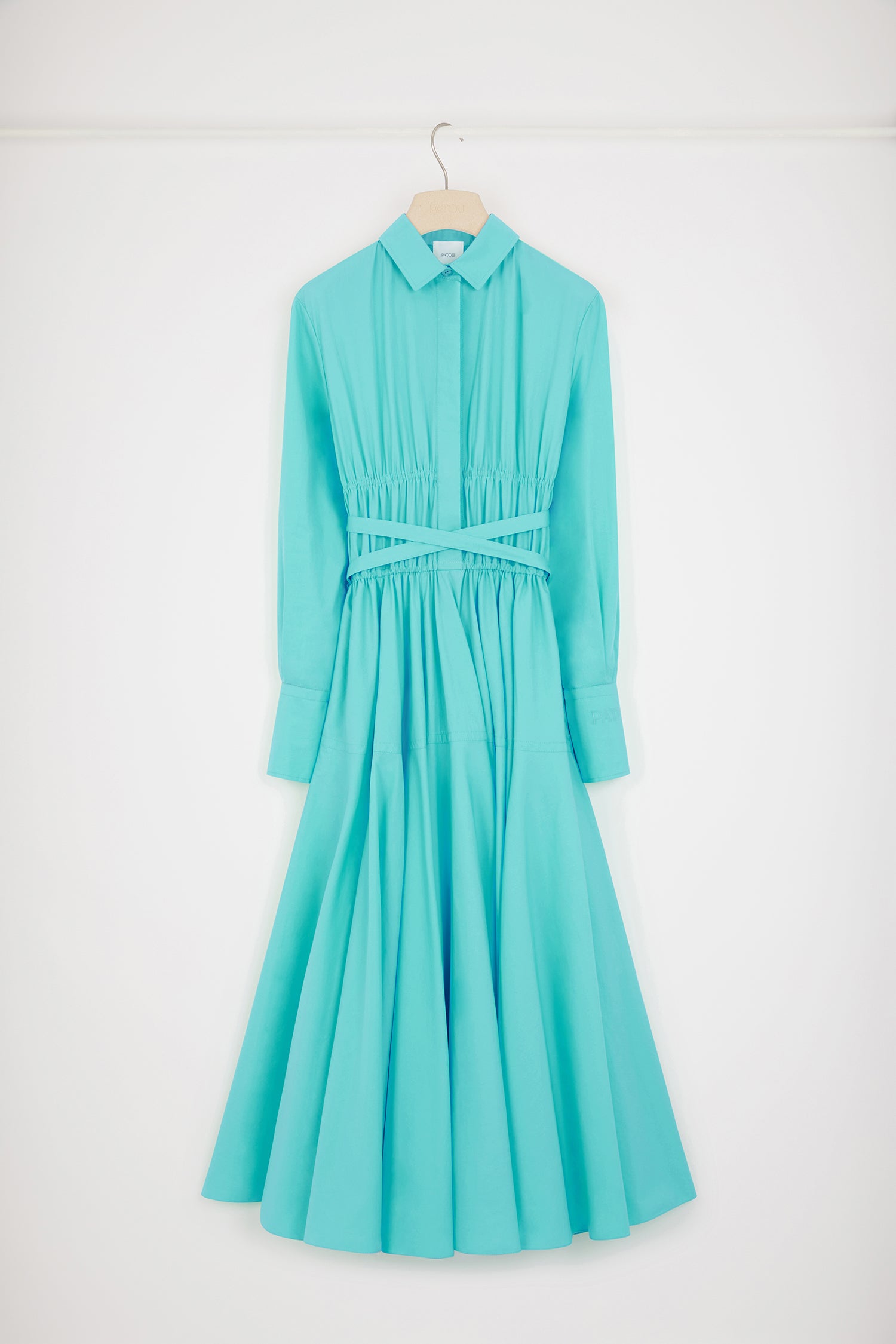 Patou - サステナブルコットン マキシ シャツドレス - Mint Green - 日々のコーデに活躍するパトゥのシャツドレスミントグリーンのサステナブルコットン ポプリンドレス。マキシ丈。シャツカラー。ティアードボディス、コンシールボタン。ウエストに細い布製ベルト。袖口にボタン、左袖にPatou刺繍。ボリューム感のあるスカート。シームポケット。