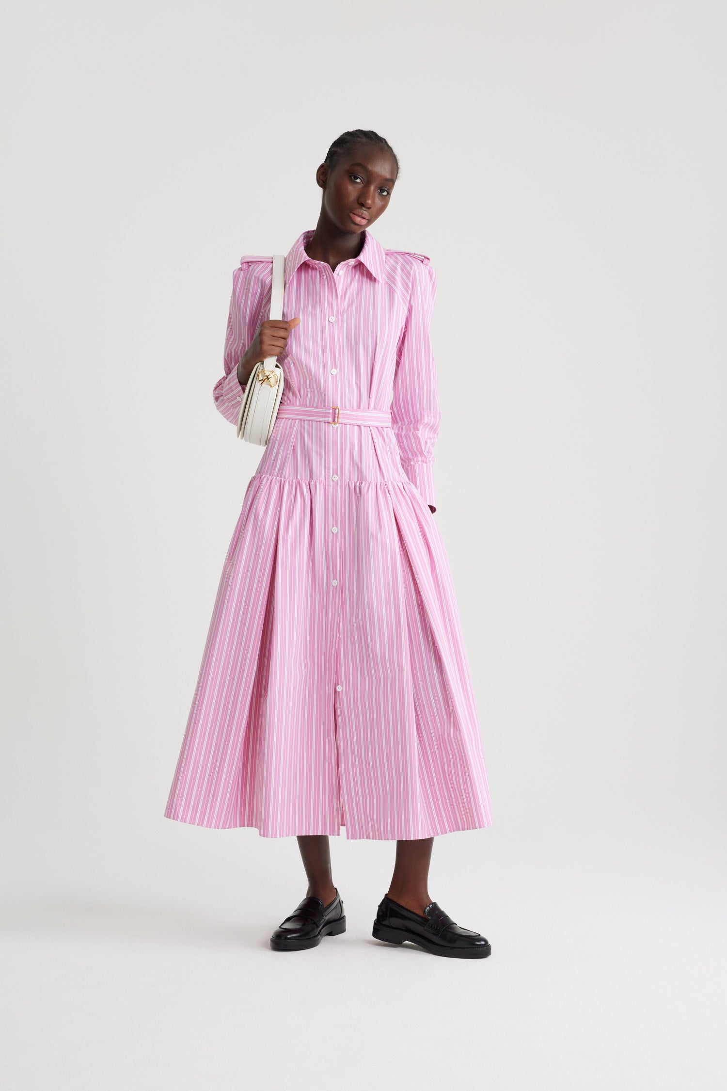 Patou - Maxi shirt dress in printed sustainable cotton - Pink Stripes - Pink sustainable cotton poplin dress. Striped pattern. Maxi length. Full volume tiered skirt. Shirt collar. JP-engraved mother-of-pearl buttons. Shoulder tabs. Raglan sleeves. Buttoned cuffs. Removable belt at the waist with gold-tone buckle.