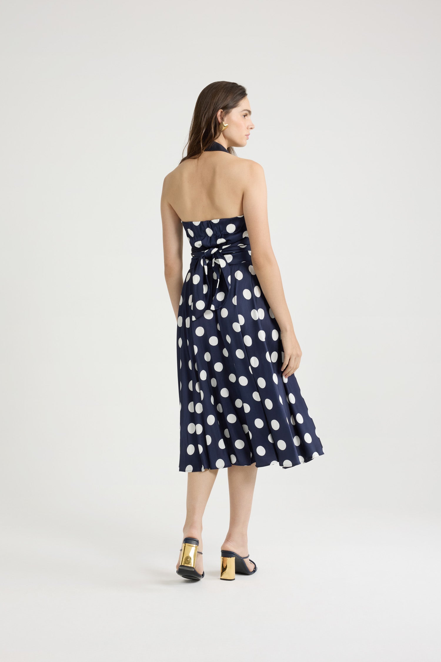 Patou - Robe midi en satin imprimé - Navy Polka Dots - Robe en satin bleu marine. Imprimé pois. Longueur midi. Bretelle tour-de-cou en gros-grain. Bustier croisé drapé à nouer au dos. Fermeture par zip doré sur le devant. Dos élastiqué.